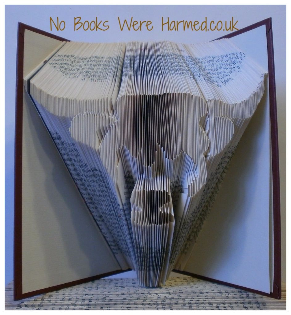 Handcrafted Scottish Highland Cow made from vintage books, showcasing unique colors and intricate hand-folding.