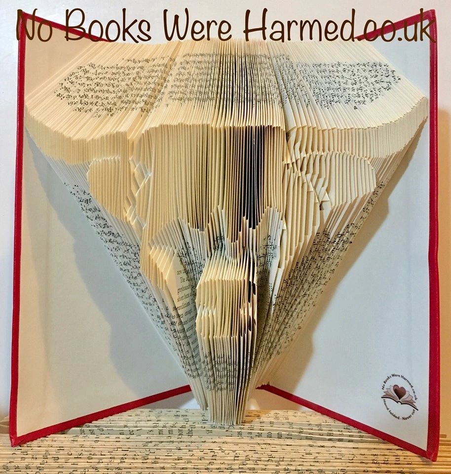 Handcrafted Scottish Highland Cow made from vintage books, showcasing unique colors and intricate hand-folding.