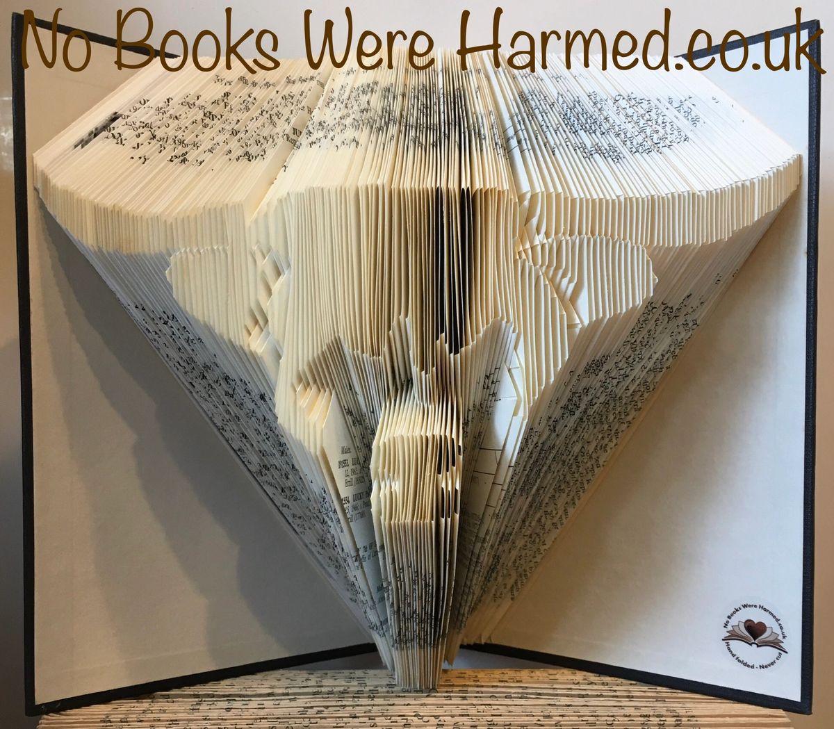 Handcrafted Scottish Highland Cow made from vintage books, showcasing unique colors and intricate hand-folding.