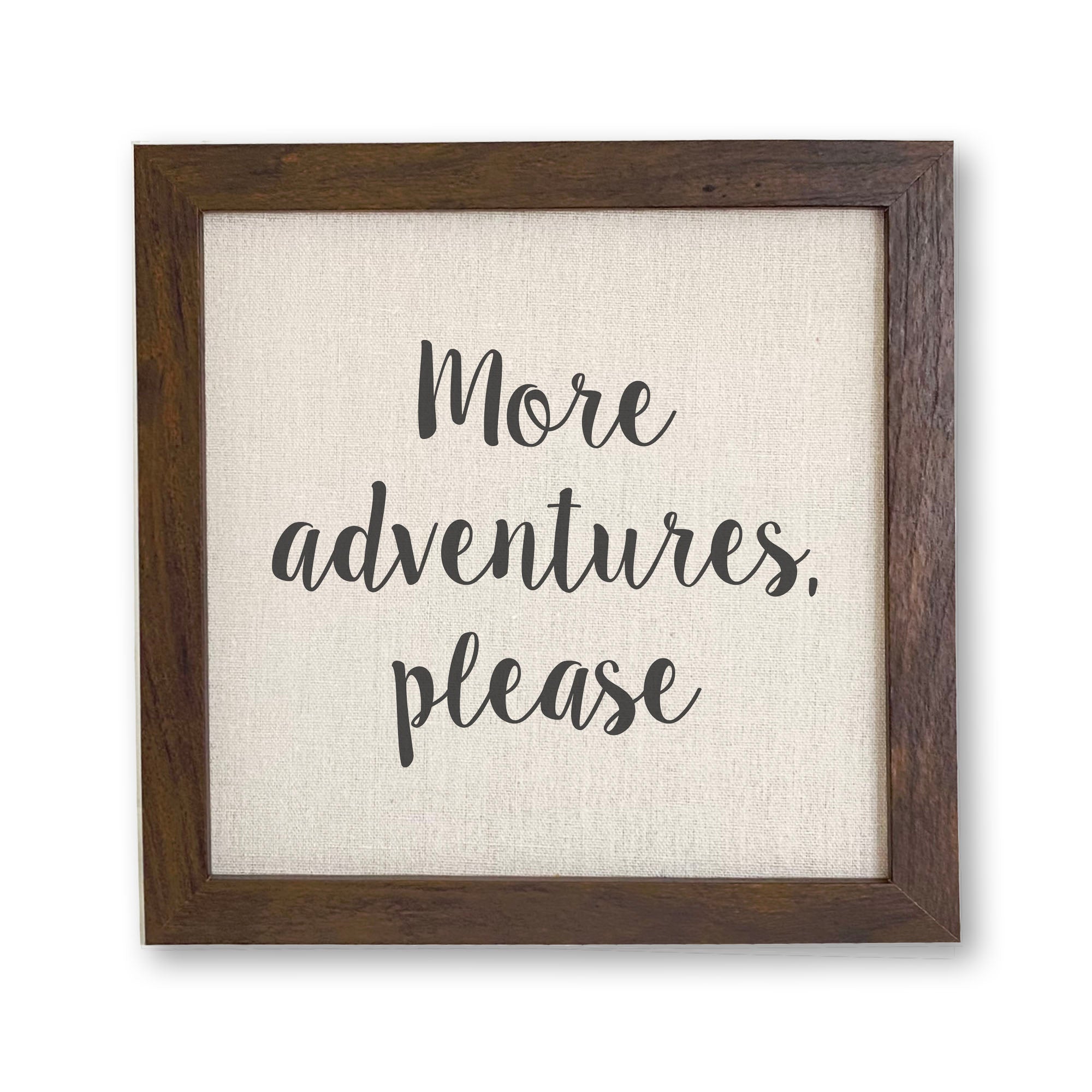 A beautifully framed sign that reads 'More Adventures Please', featuring a natural wood frame and a linen-look neutral background.