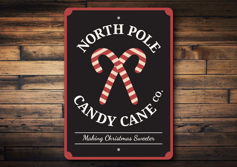 North Pole Candy Cane Company decorative sign made of aluminum, featuring festive colors and a charming design perfect for Christmas decorations.