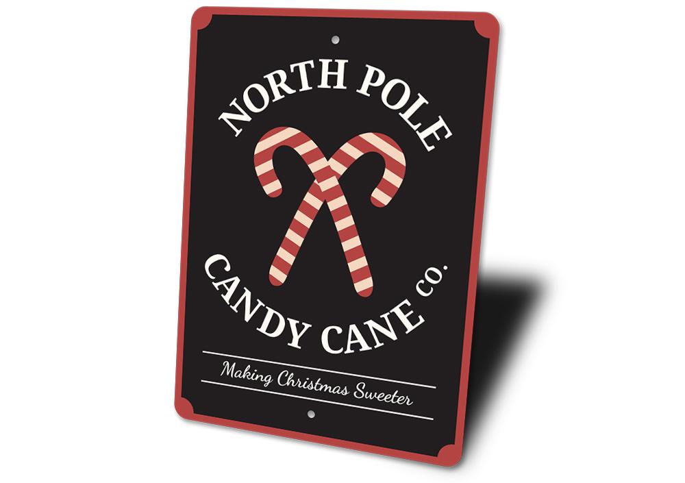 North Pole Candy Cane Company decorative sign made of aluminum, featuring festive colors and a charming design perfect for Christmas decorations.