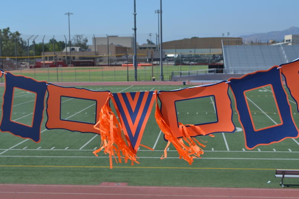 Orange and white paper frames, pennant, ribbon, and tassels for festive decor.