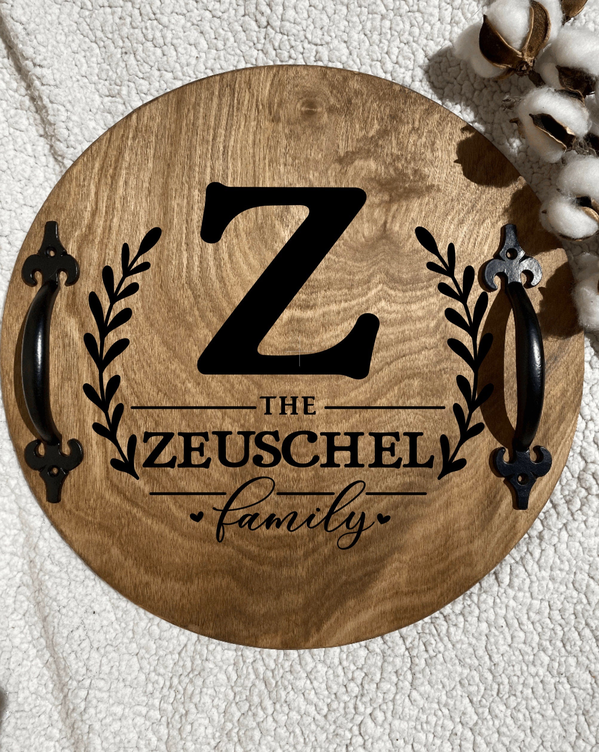 Personalized wooden serving tray with family name and initial, featuring black metal handles and rich chestnut finish.
