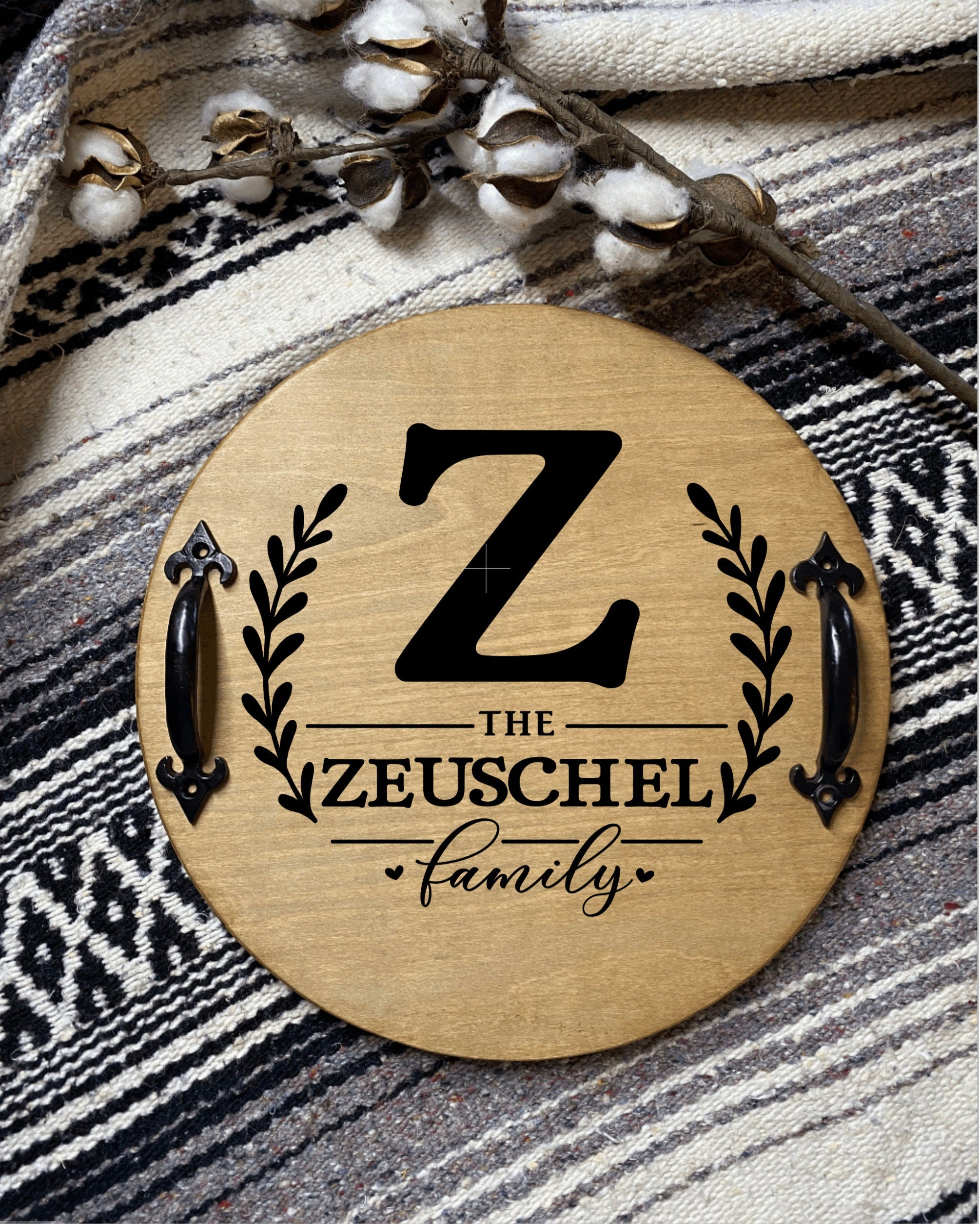 Personalized wooden serving tray with family name and initial, featuring black metal handles and rich chestnut finish.