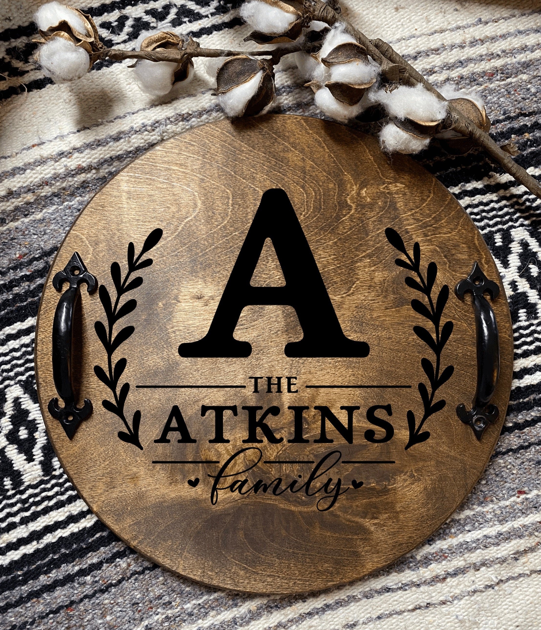 Personalized wooden serving tray with family name and initial, featuring black metal handles and rich chestnut finish.