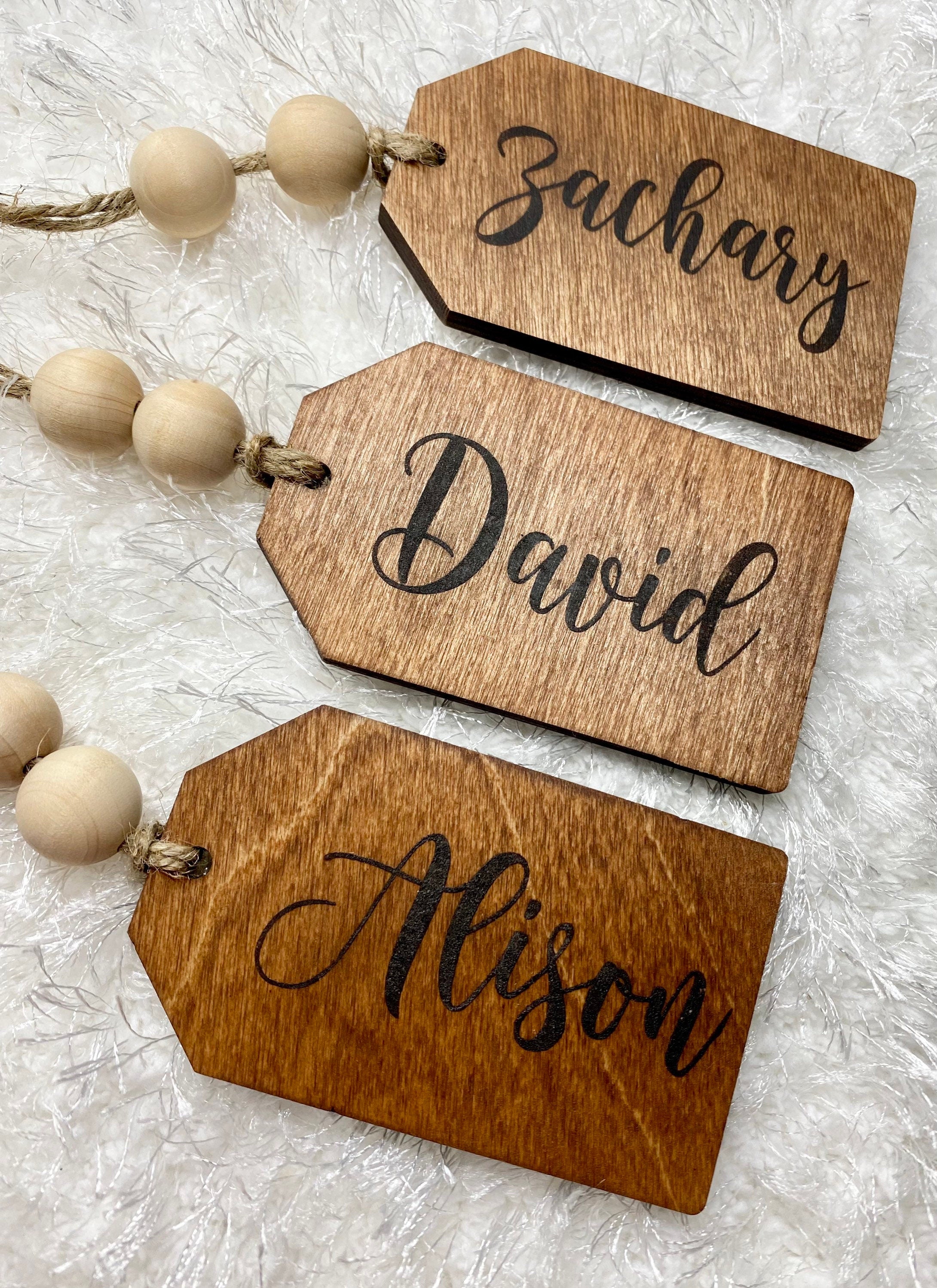 Personalized wooden gift tags made of birch plywood with twine and wooden beads, perfect for various occasions.