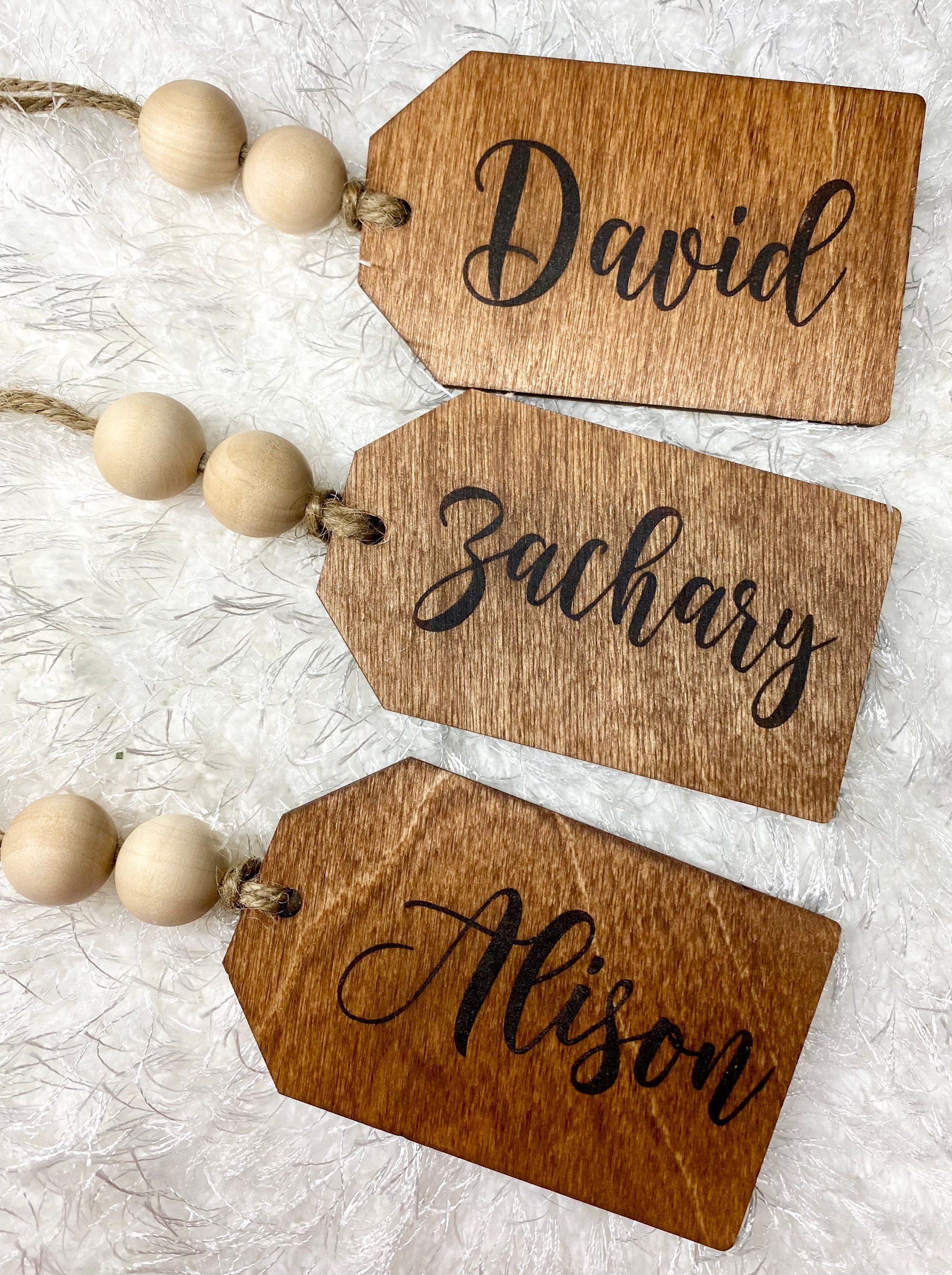 Personalized wooden gift tags made of birch plywood with twine and wooden beads, perfect for various occasions.