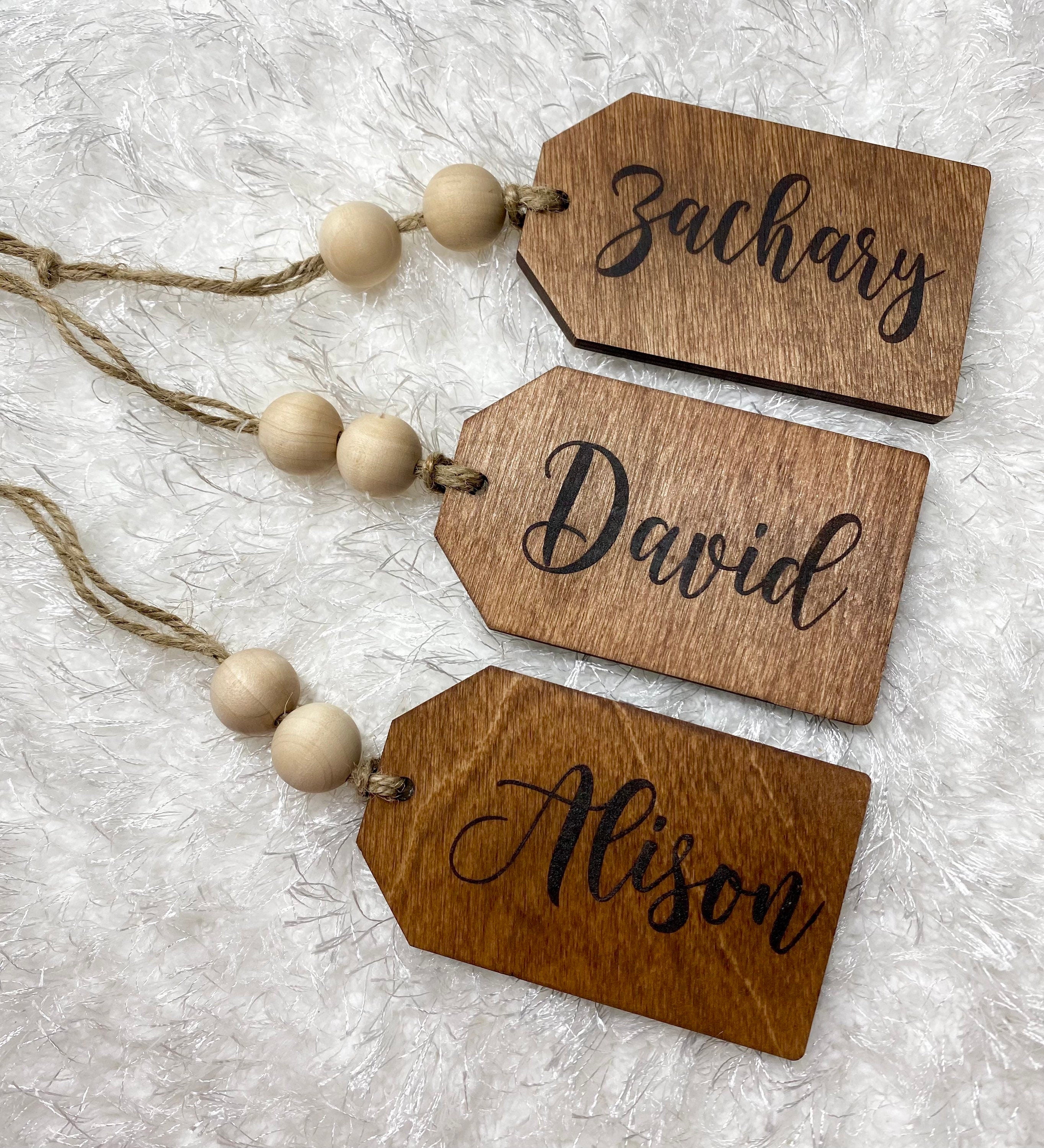 Personalized wooden gift tags made of birch plywood with twine and wooden beads, perfect for various occasions.