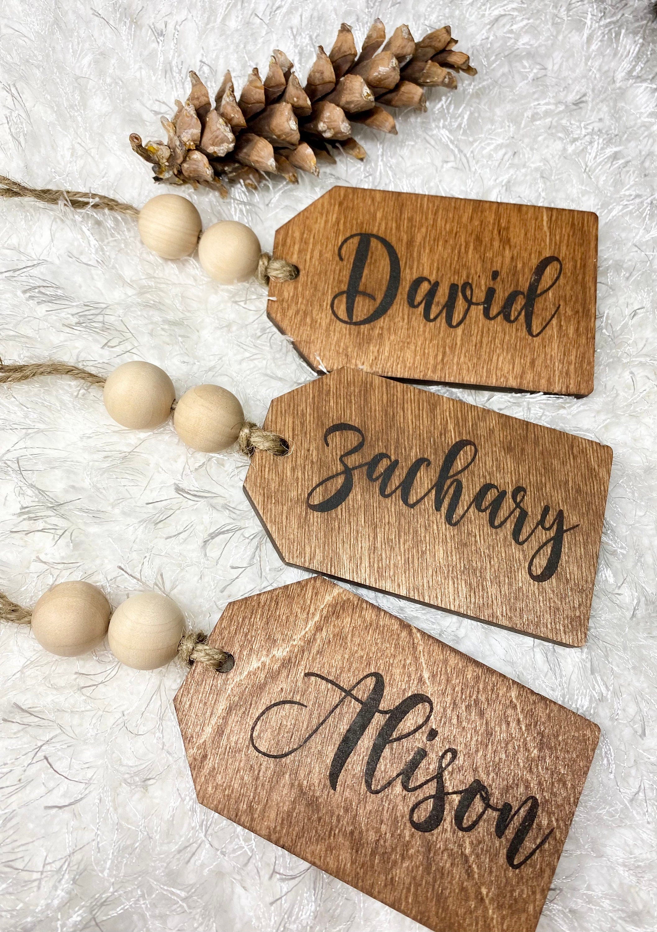 Personalized wooden gift tags made of birch plywood with twine and wooden beads, perfect for various occasions.