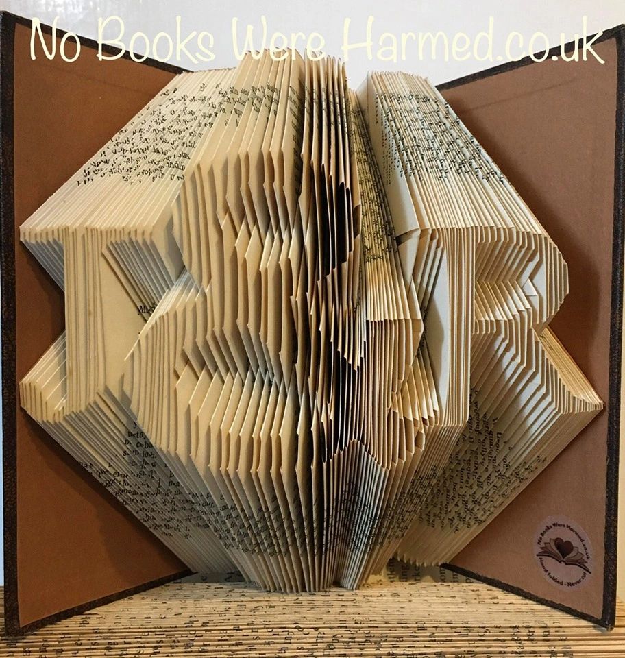 Hand-folded book art featuring personalized initials and an ampersand, crafted from vintage pages.