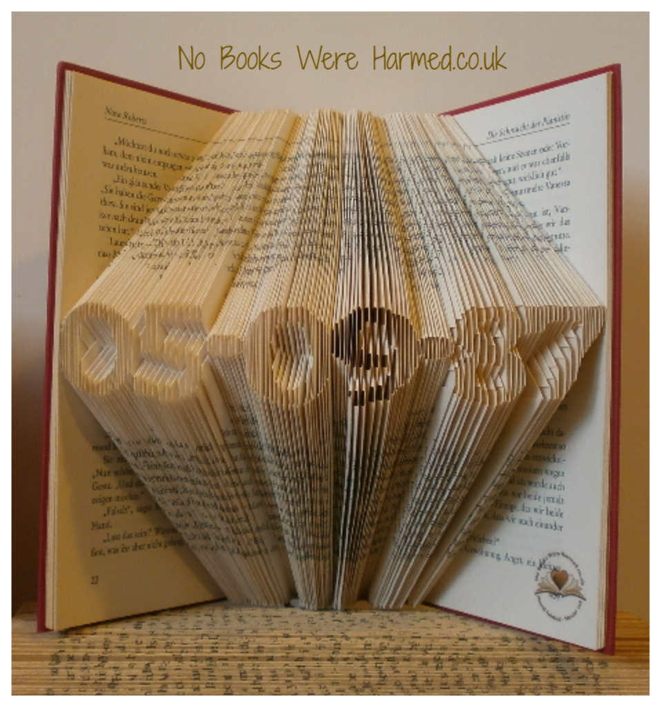 A beautifully crafted mini personalised keepsake date made from vintage book pages, showcasing intricate hand-folded designs.