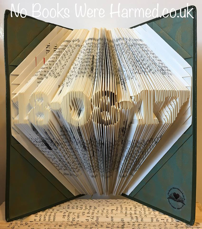 A beautifully crafted mini personalised keepsake date made from vintage book pages, showcasing intricate hand-folded designs.