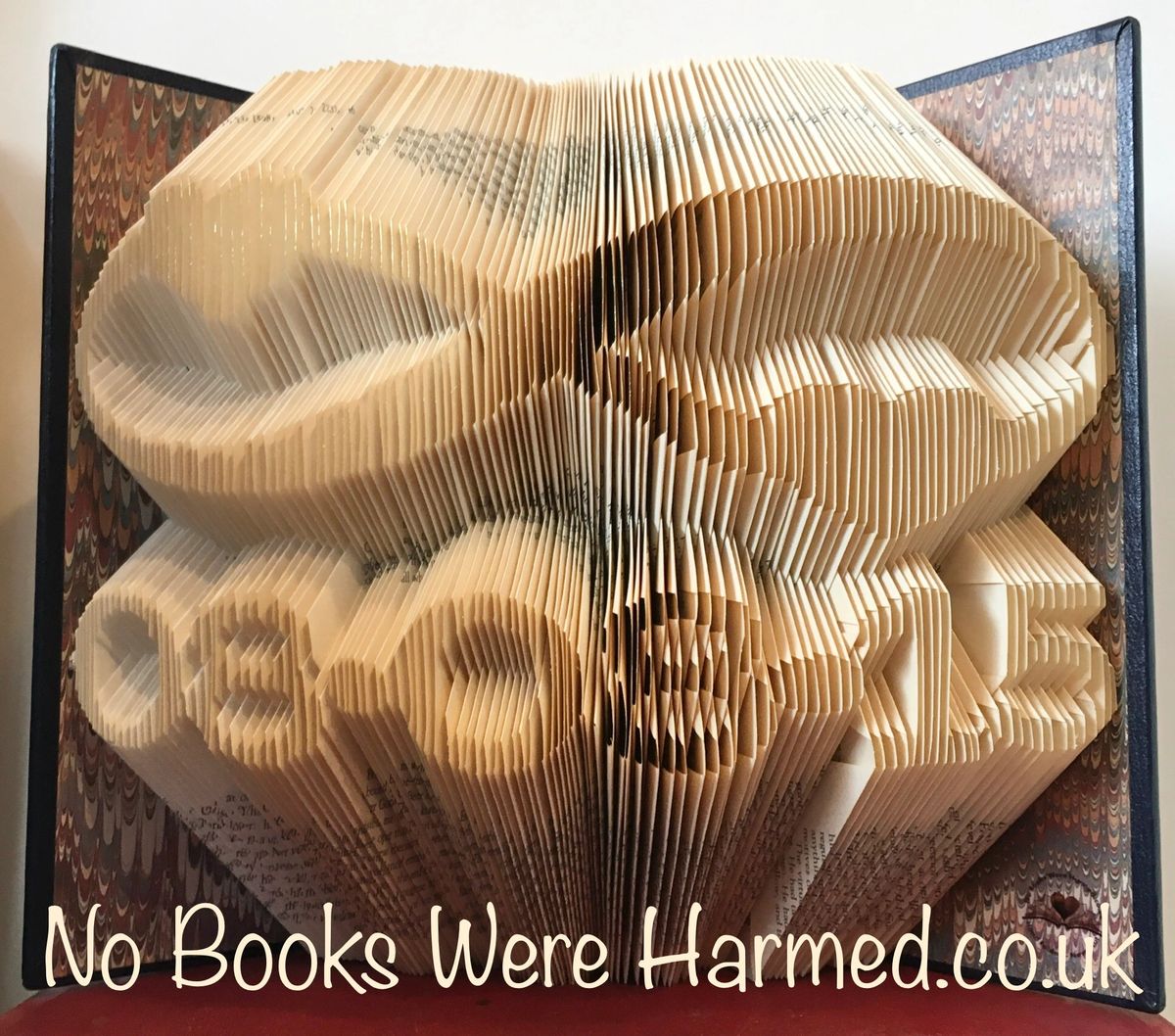 Personalised keepsake featuring a custom date beneath a heart-adorned infinity symbol, crafted from vintage book pages.