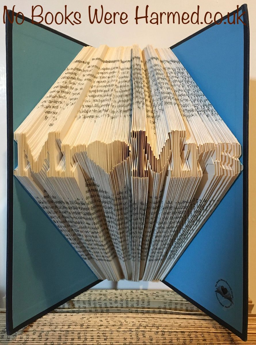Hand-folded book art displaying a custom word, showcasing unique vintage pages and intricate lettering.