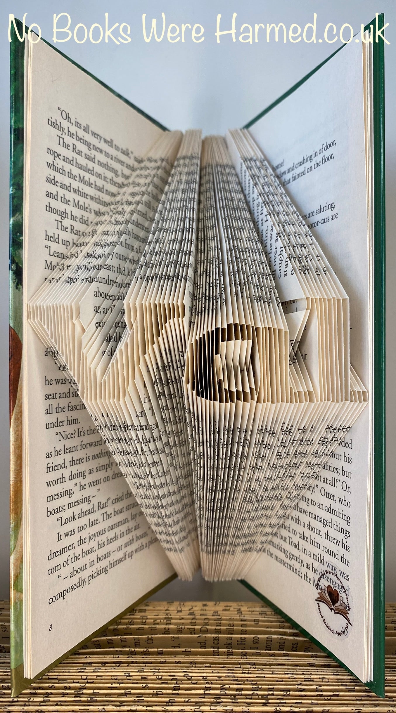 Hand-folded book art displaying a custom word, showcasing unique vintage pages and intricate lettering.