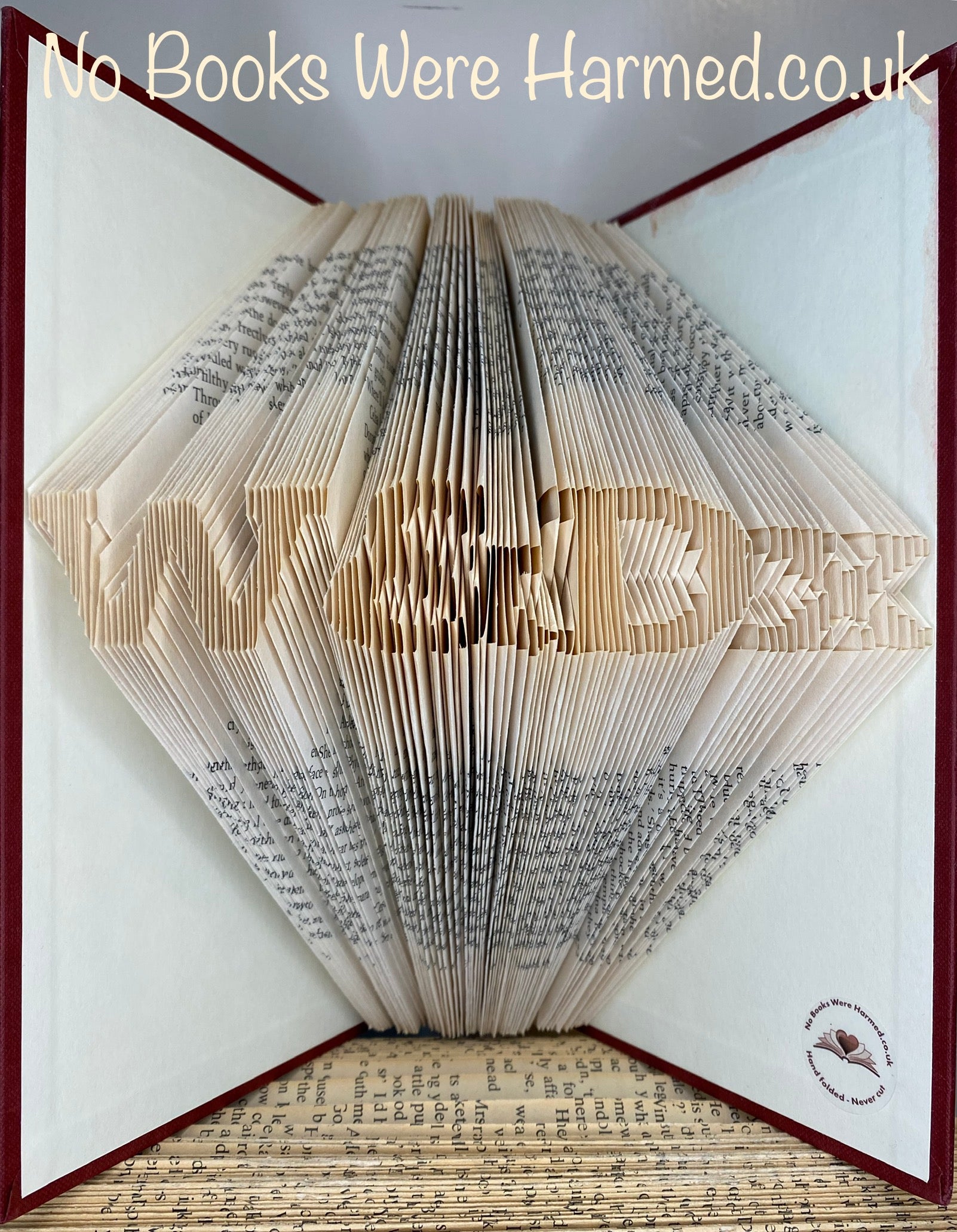 Hand-folded book art displaying a custom word, showcasing unique vintage pages and intricate lettering.