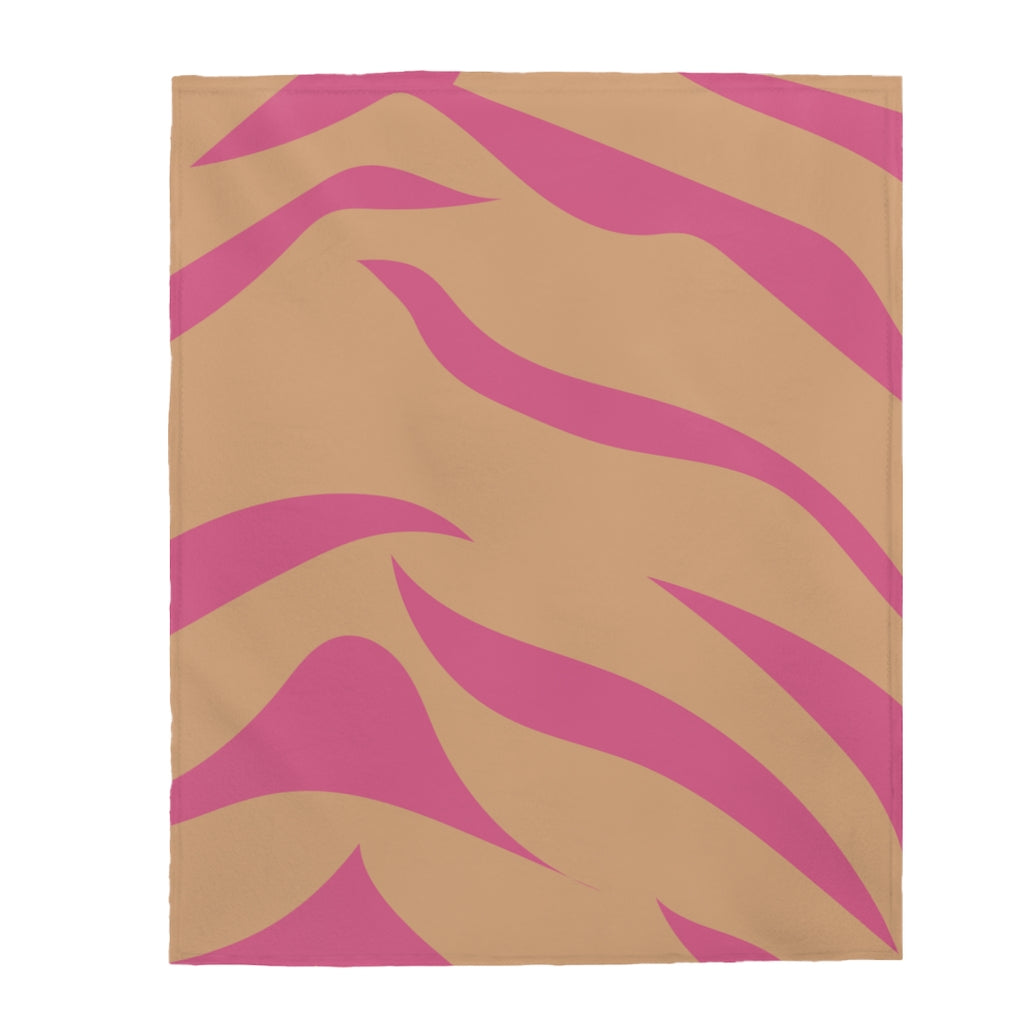 A cozy pink and orange leopard stripes plush throw blanket draped elegantly over a couch, showcasing its soft velveteen texture and vibrant colors.