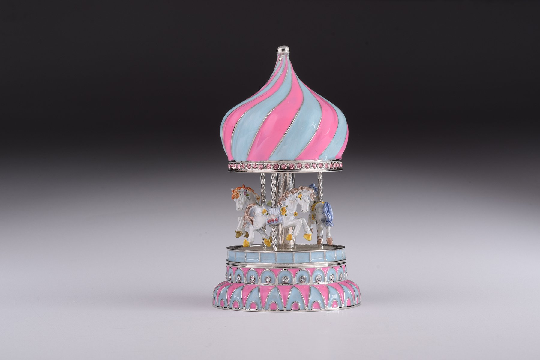 A beautifully crafted Pink Wind up Musical Carousel trinket box, adorned with Austrian crystals and plated with 24K Gold or 925 Silver.