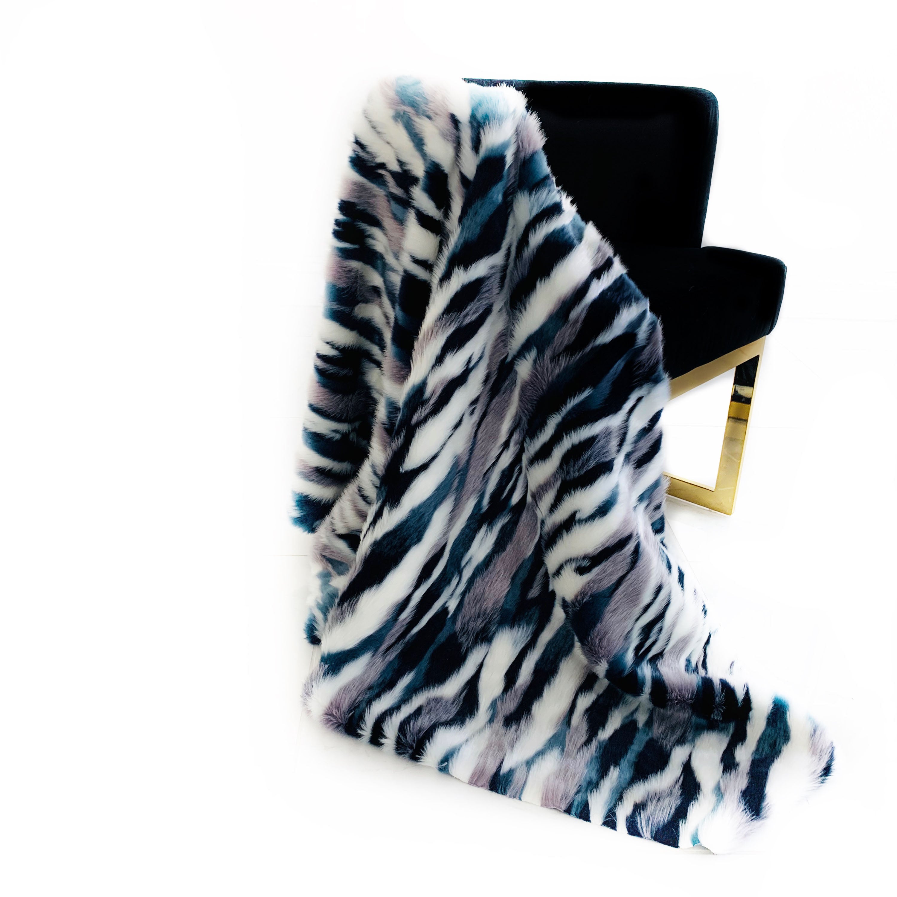 Plutus Blue, Black, White Fancy Faux Fur Luxury Throw Blanket displayed elegantly on a couch, showcasing its plush texture and reversible design.