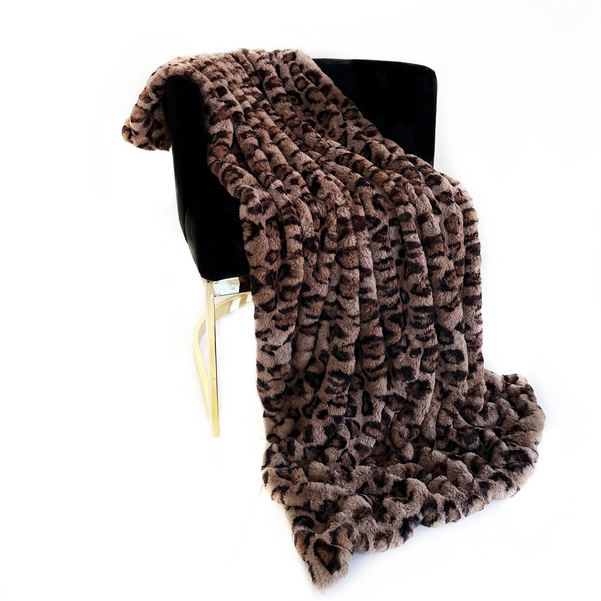 Plutus Brown Leopard Faux Fur Luxury Throw Blanket draped elegantly over a couch, showcasing its rich brown leopard pattern and soft texture.