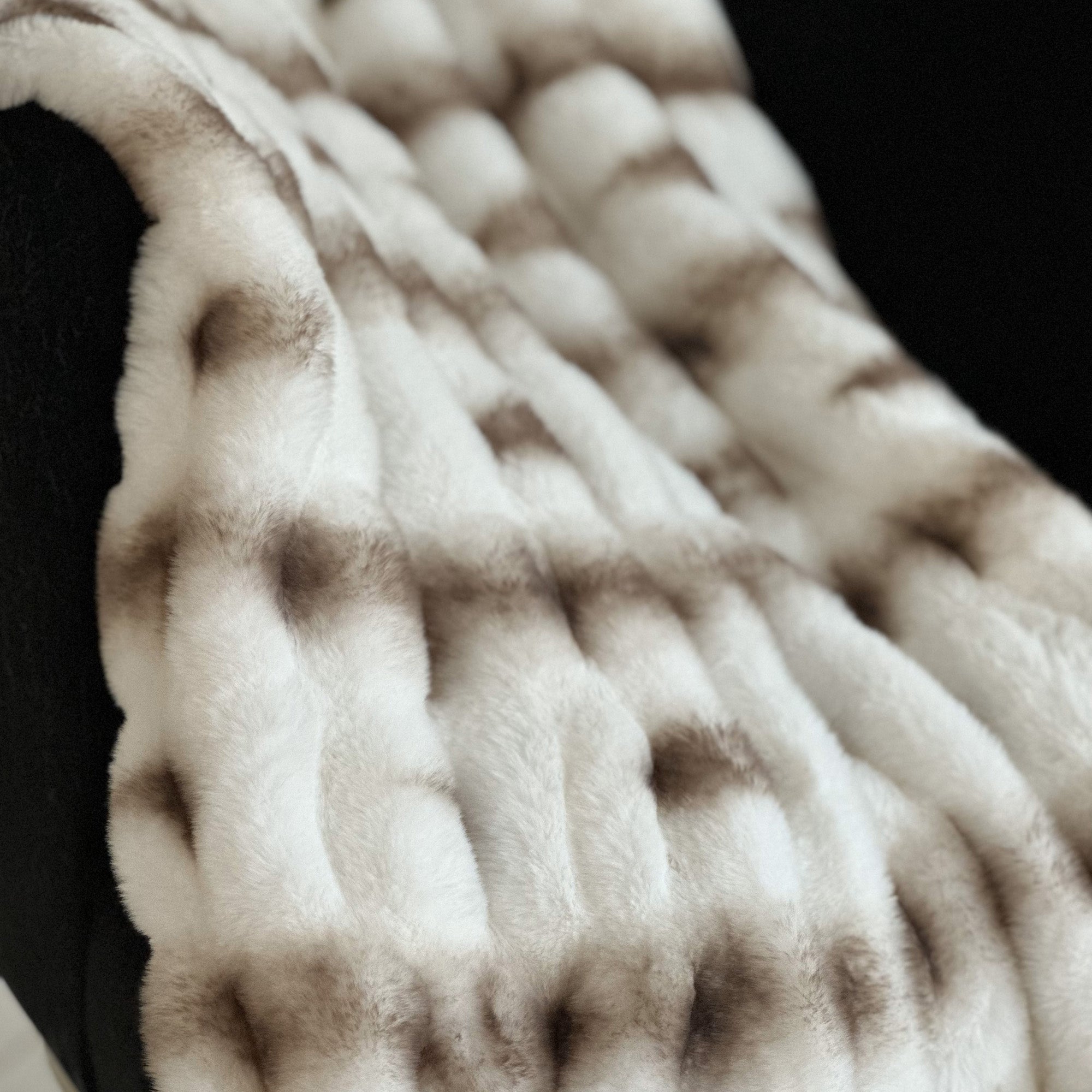 Plutus Creamy Fluffy Bunni Faux Fur Luxury Throw Blanket in a cozy setting, showcasing its soft texture and elegant creamy color.