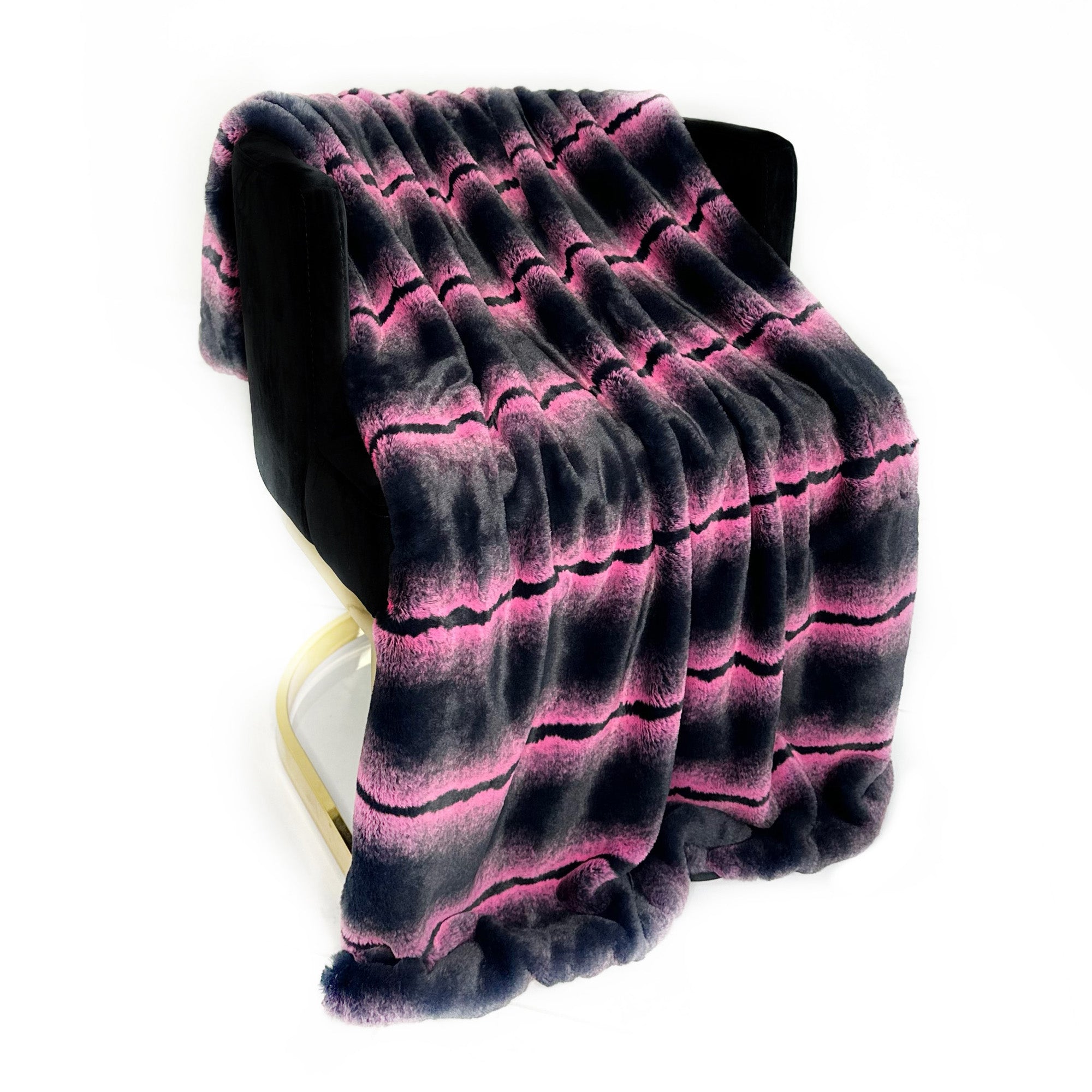 Plutus Fuchsia Black Fluffy Fields Faux Fur Luxury Throw Blanket draped elegantly over a chair, showcasing its plush texture and vibrant color.