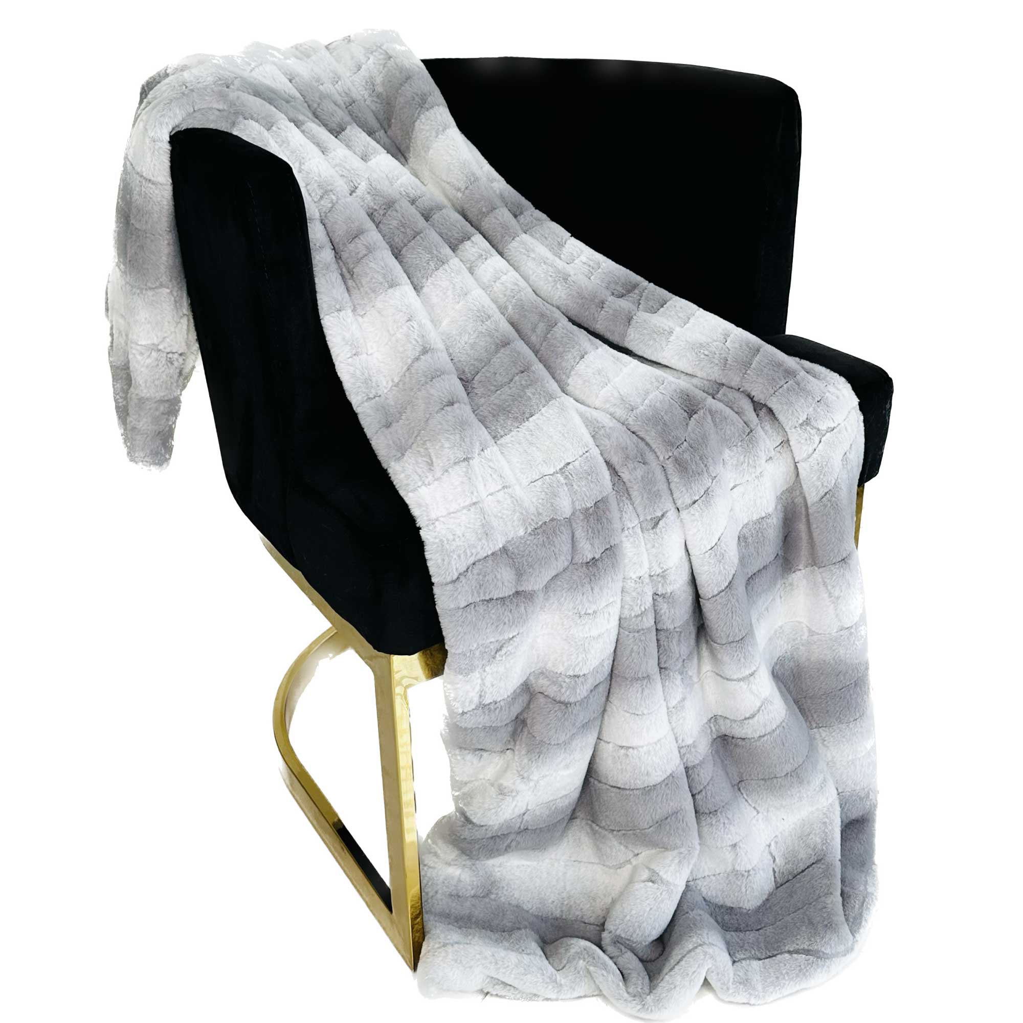 Plutus Gray Silver Furever Faux Fur Luxury Throw Blanket draped elegantly on a couch, showcasing its plush texture and reversible design.