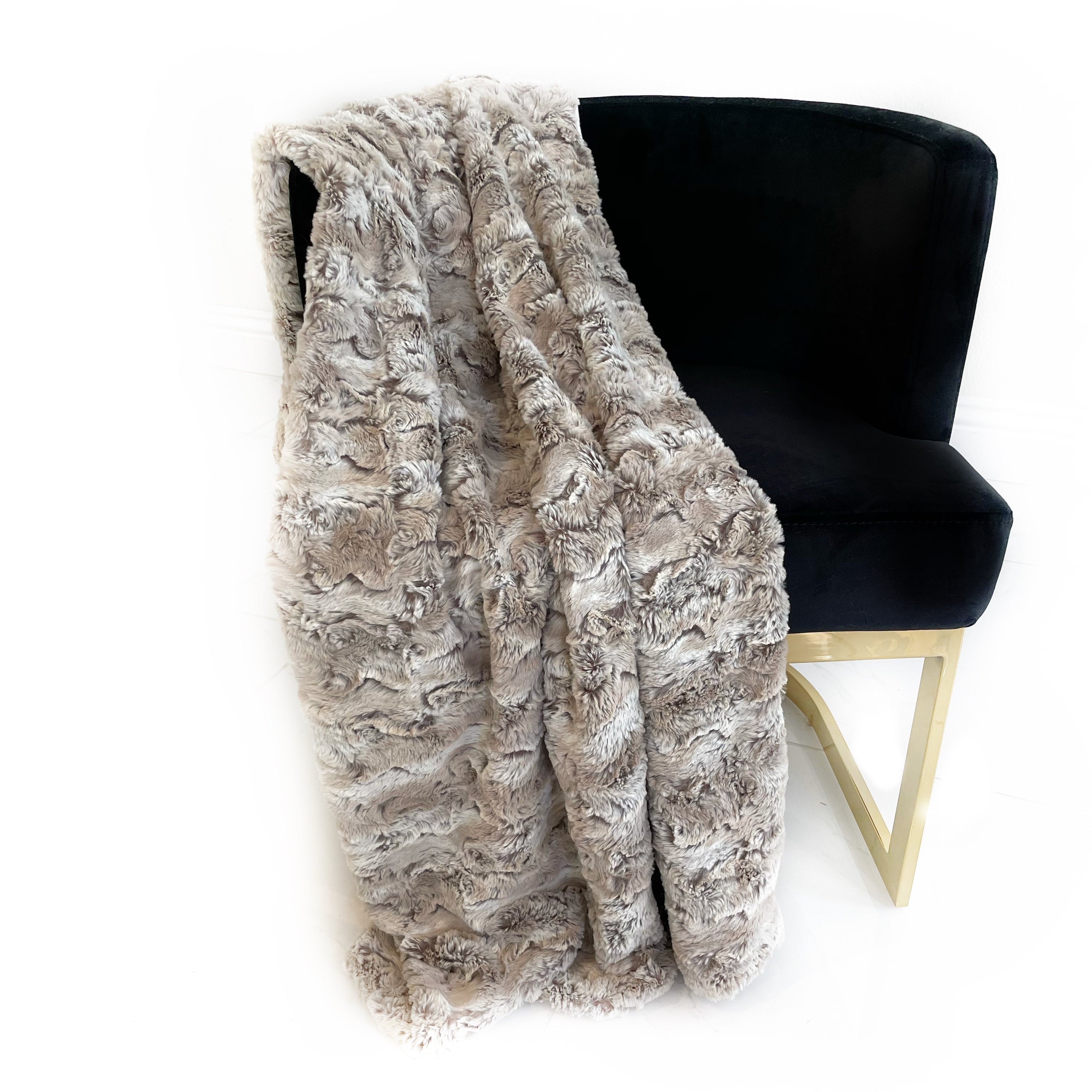 Plutus Light Brown Wild Rabbit Faux Fur Luxury Throw Blanket draped elegantly over a couch, showcasing its plush texture and reversible design.