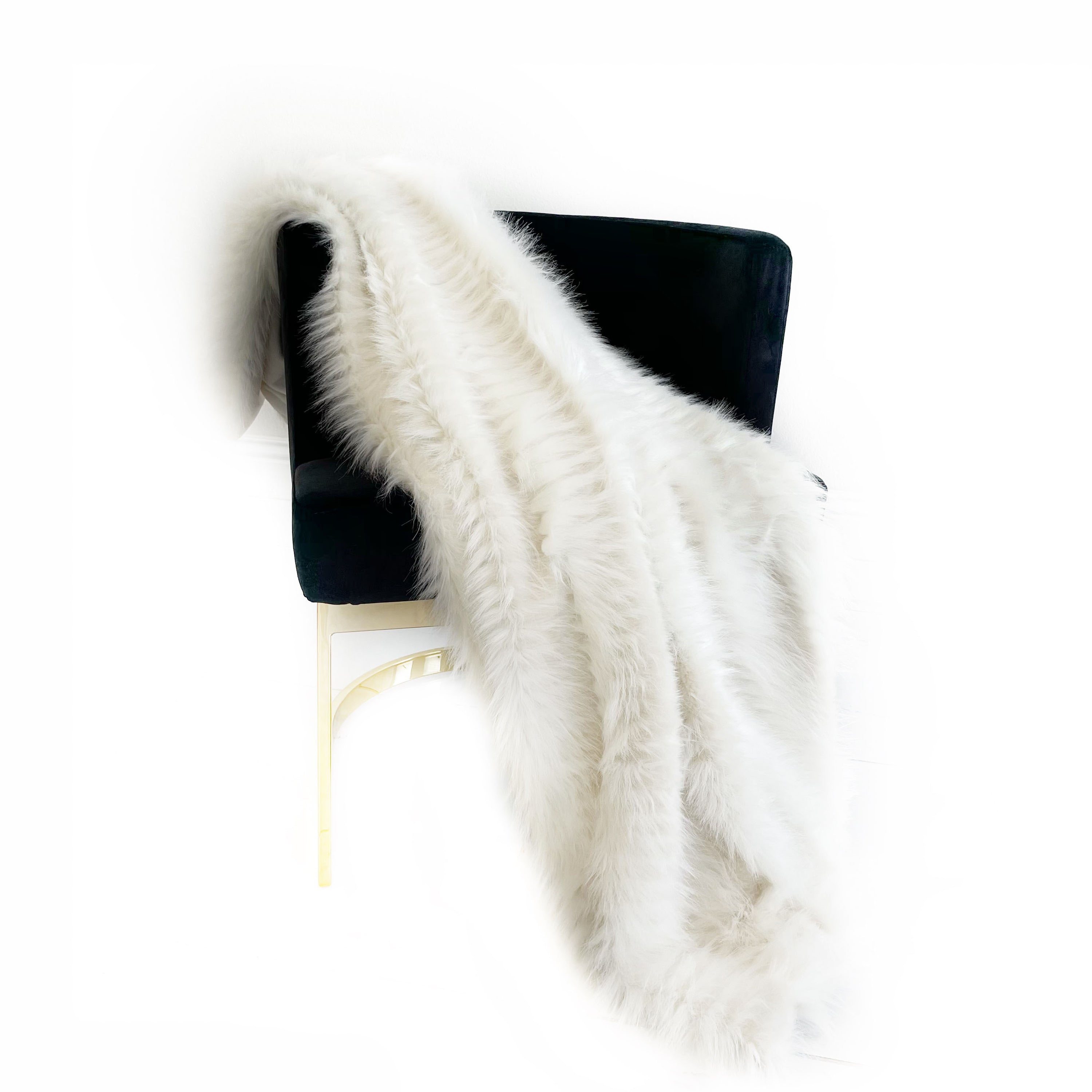 Plutus Off White Exotic Ostrich Feather Faux Fur Luxury Throw Blanket draped elegantly on a sofa, showcasing its plush texture and reversible design.