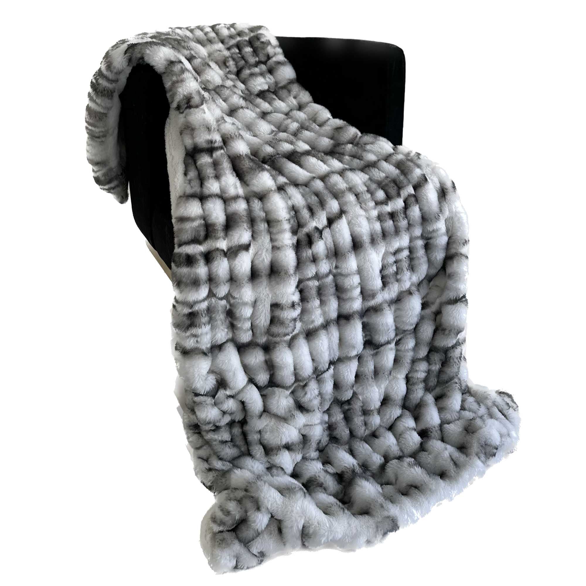 Plutus Off White Sherpa Faux Fur Luxury Throw Blanket draped elegantly over a sofa, showcasing its plush texture and reversible design.