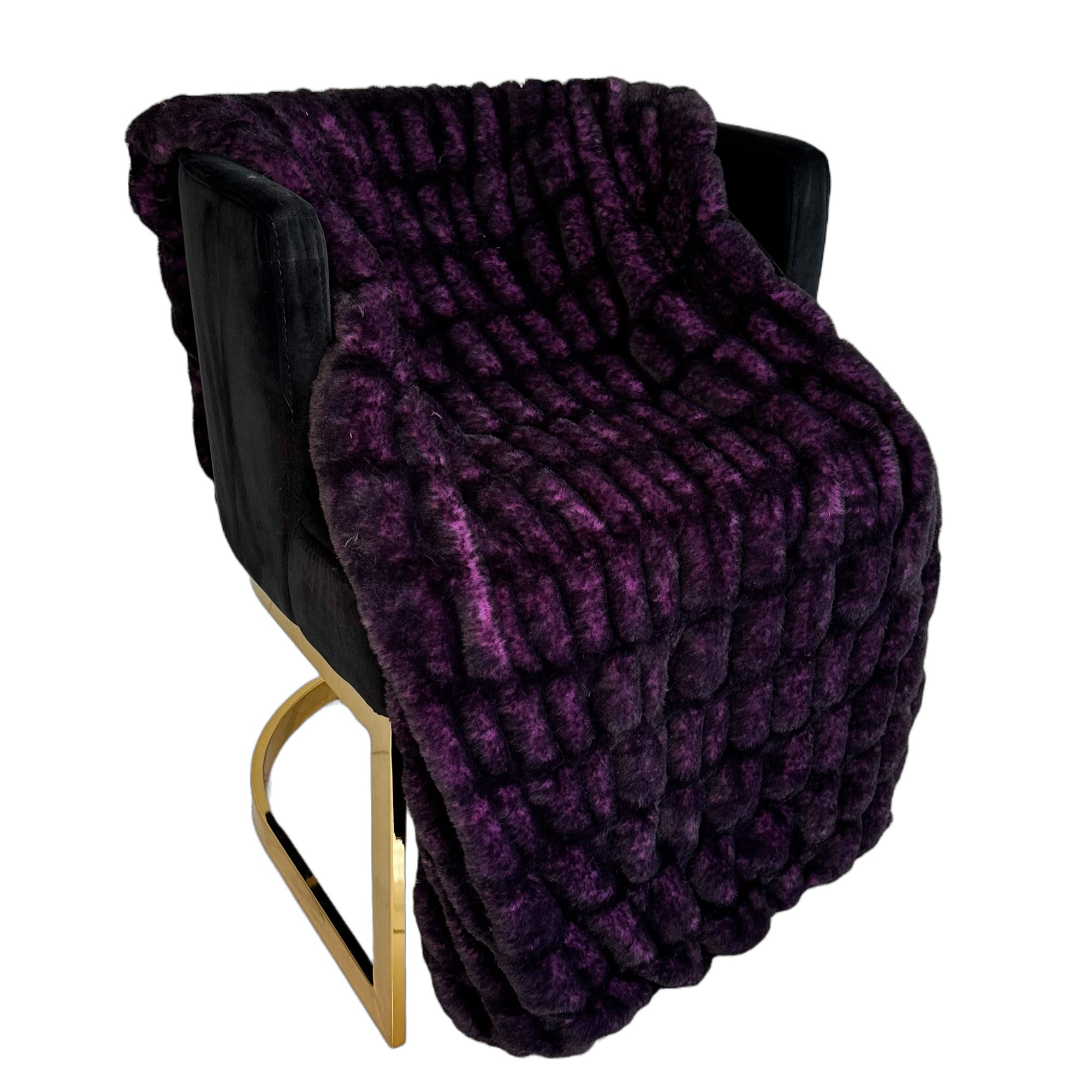 Plutus Purple Plush Pelt Faux Fur Luxury Throw Blanket draped elegantly on a couch, showcasing its rich purple color and soft texture.