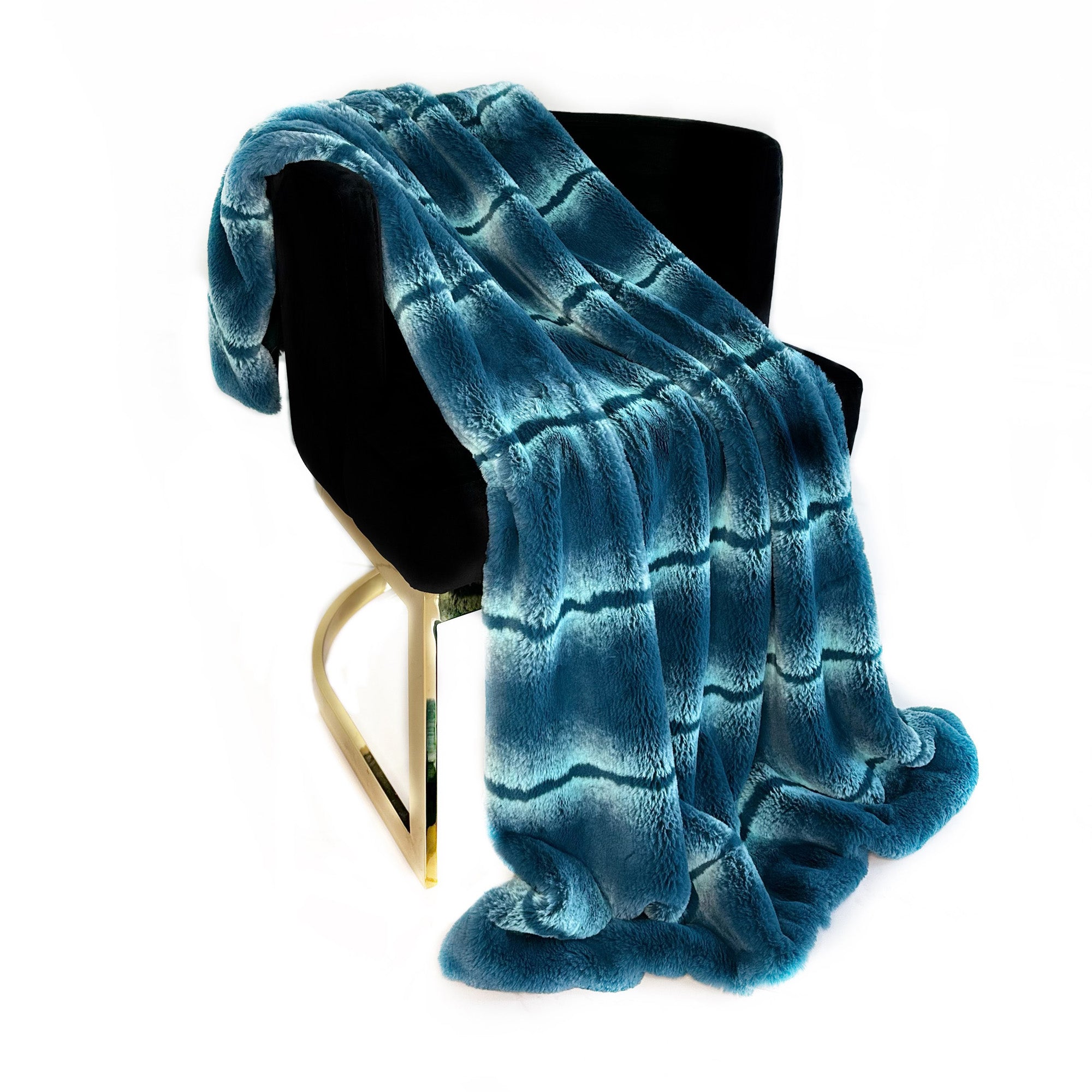 Plutus Teal Fluffy Fields Faux Fur Luxury Throw Blanket draped elegantly on a couch, showcasing its soft texture and vibrant teal color.
