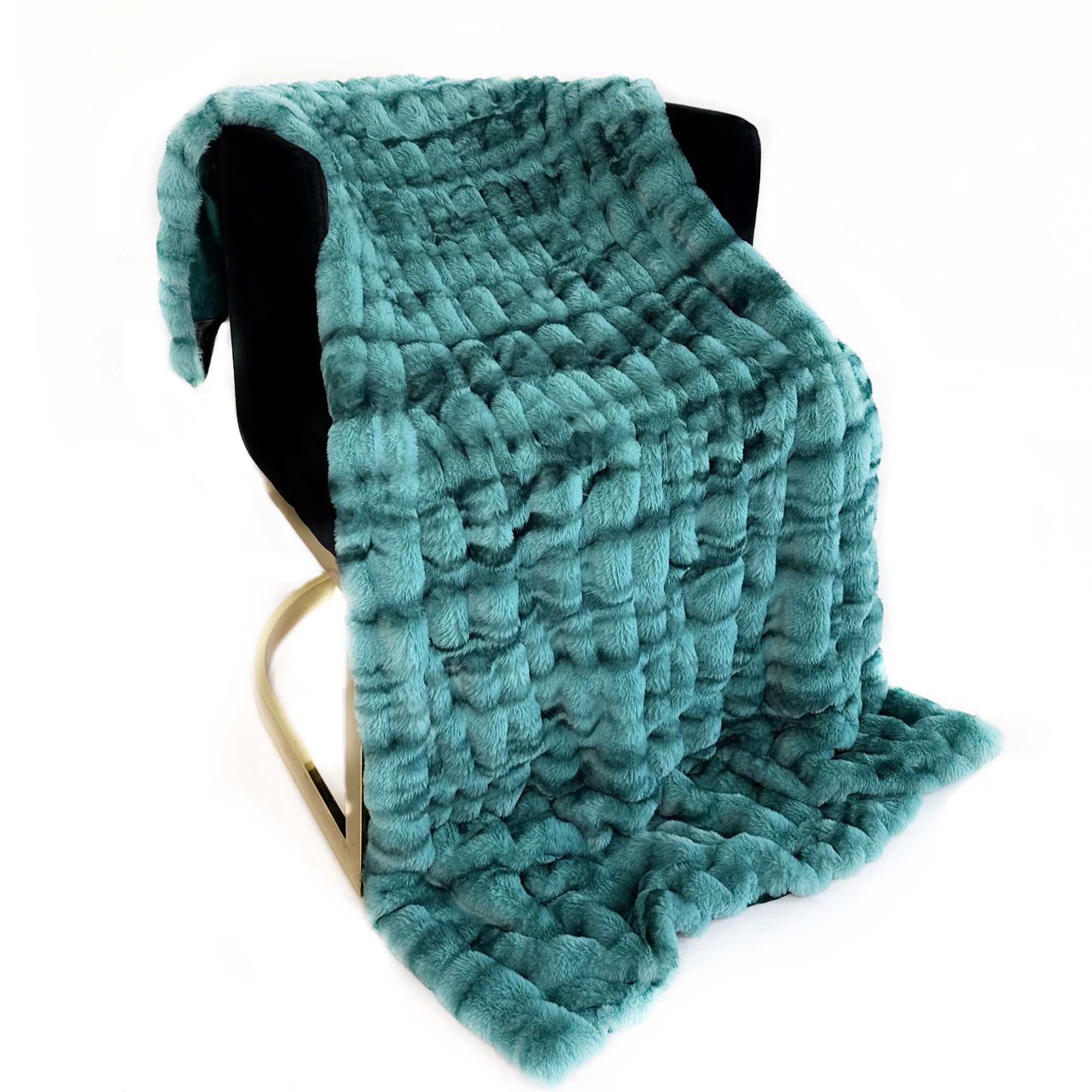 Plutus Teal Sherpa Faux Fur Luxury Throw Blanket draped elegantly on a couch, showcasing its soft texture and vibrant teal color.