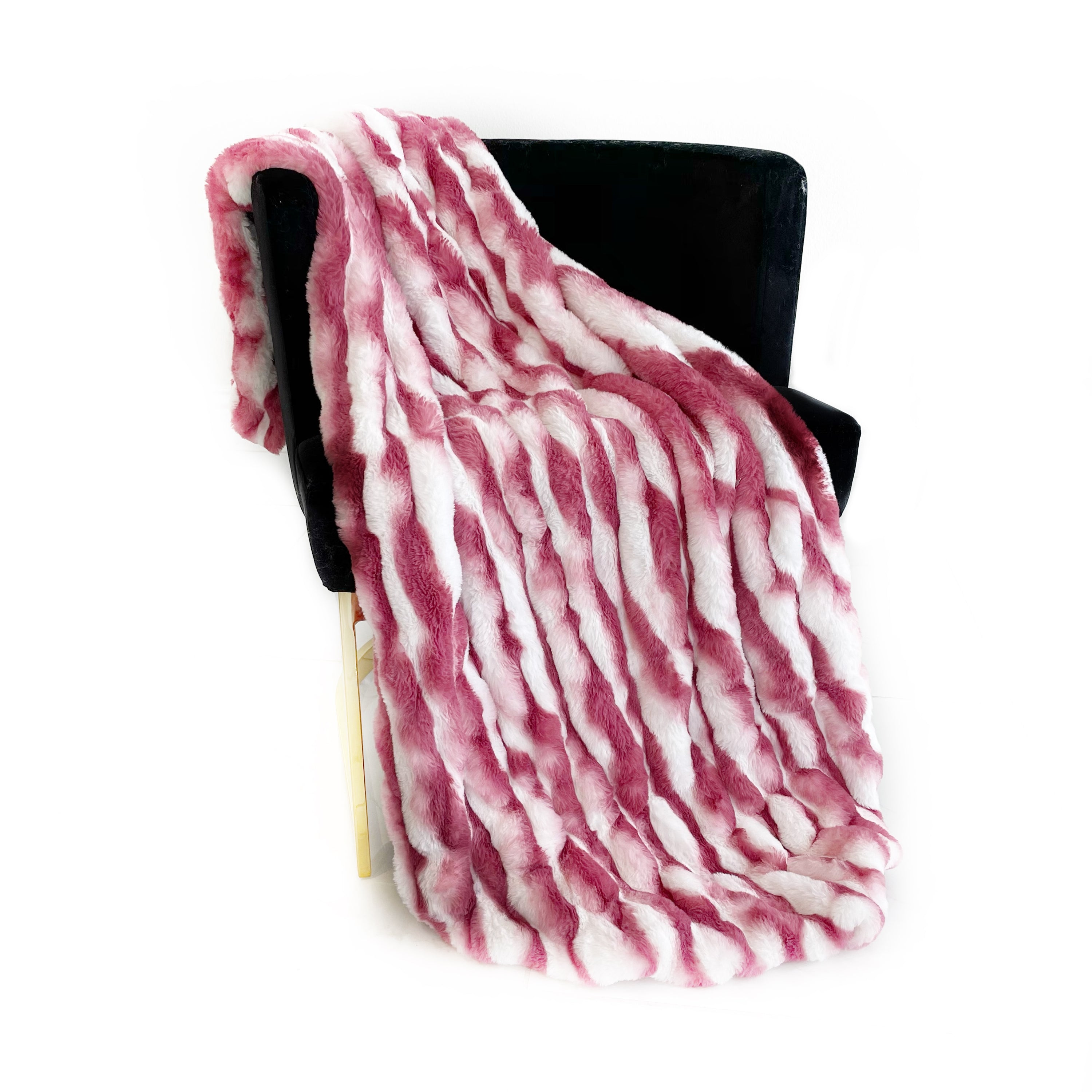 Plutus White Berry Snow Chinchilla Faux Fur Luxury Throw Blanket draped elegantly over a sofa, showcasing its soft texture and trendy color.