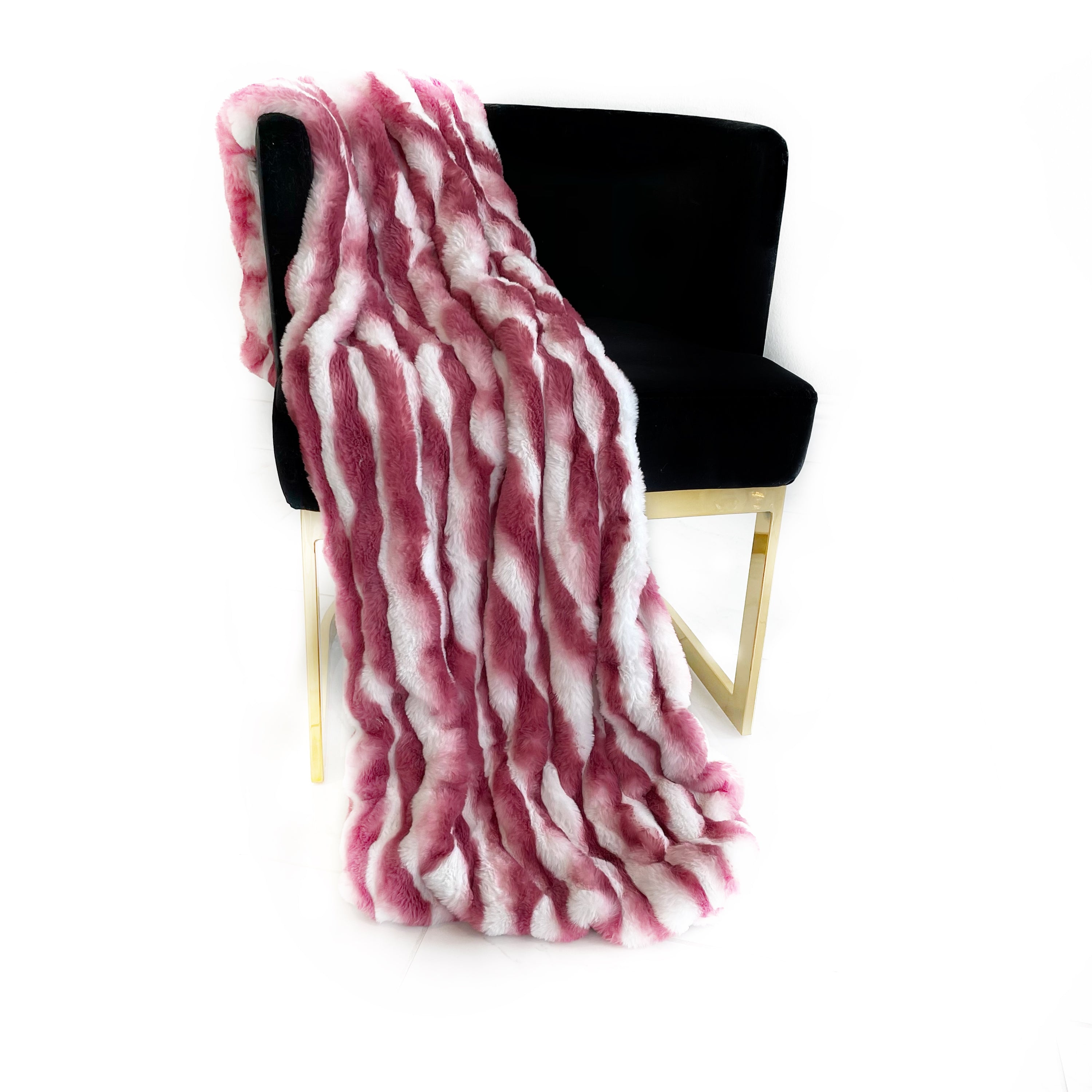 Plutus White Berry Snow Chinchilla Faux Fur Luxury Throw Blanket draped elegantly over a sofa, showcasing its soft texture and trendy color.