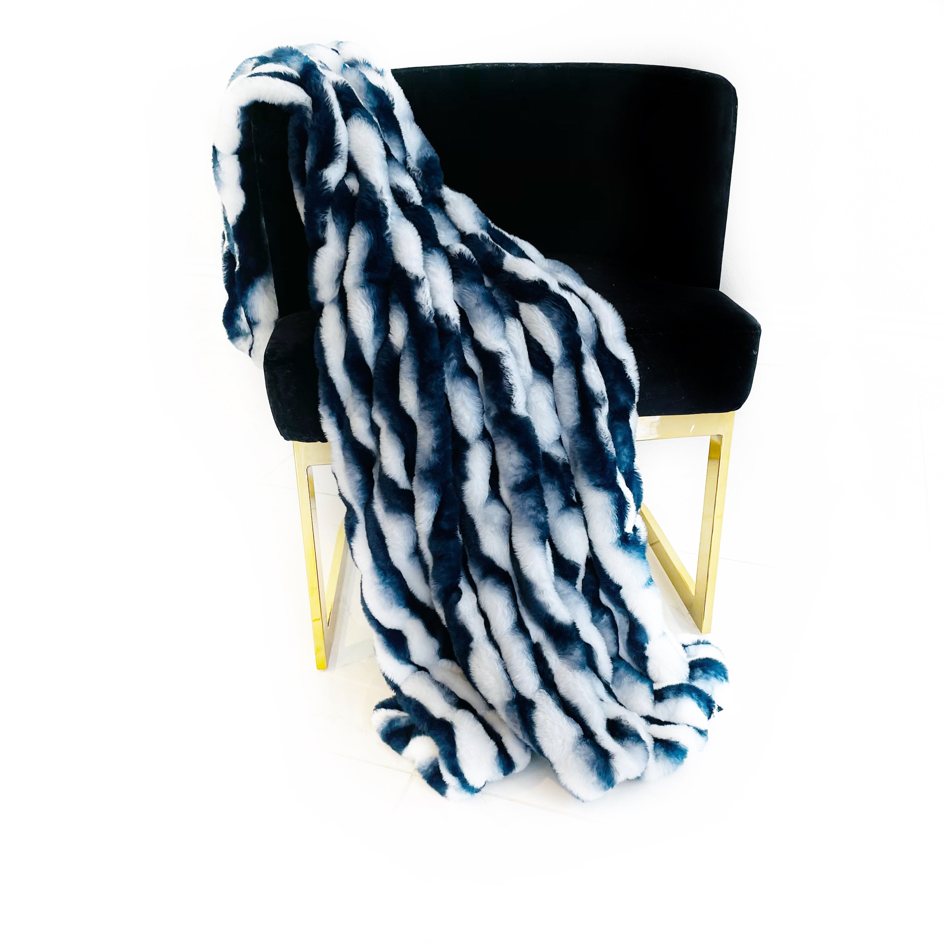 Plutus White Navy Snow Chinchilla Faux Fur Luxury Throw Blanket draped elegantly on a couch, showcasing its soft texture and stylish color combination.