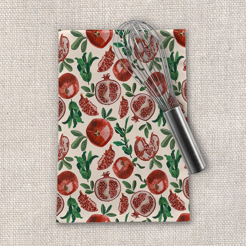 A vibrant pomegranate tea towel made of cotton twill, featuring a colorful pomegranate design, perfect for kitchen use.