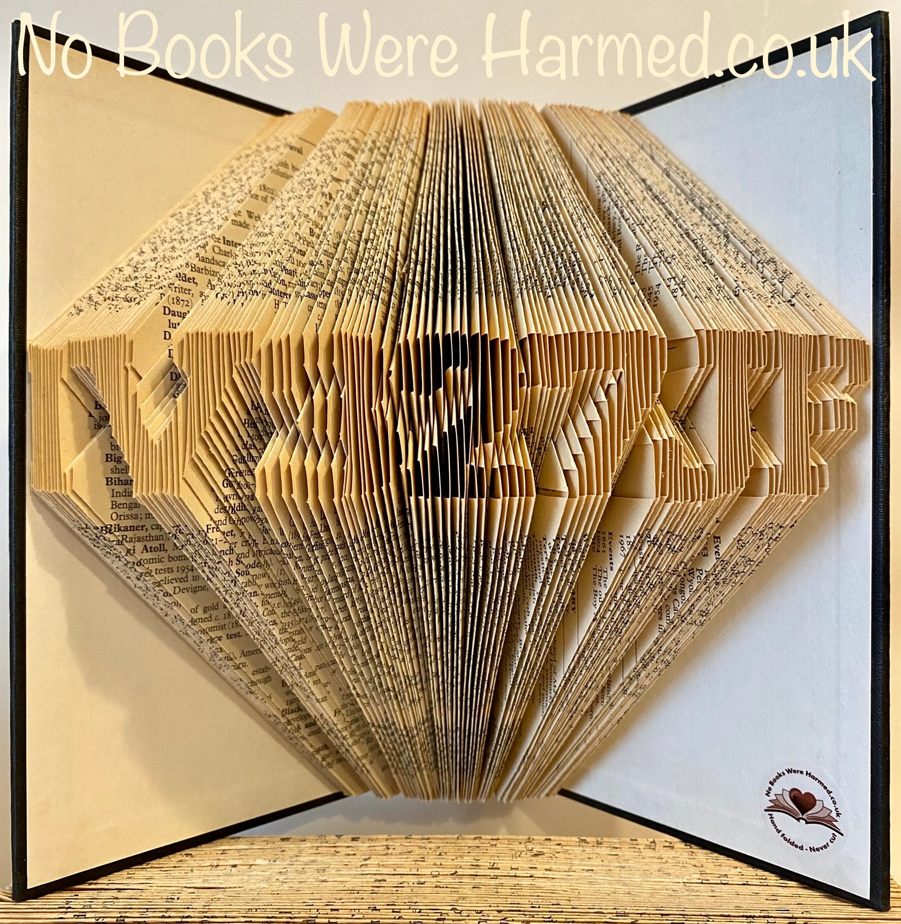 Hand folded book art sculpture displaying a postcode, crafted from vintage books with intricate page folds.