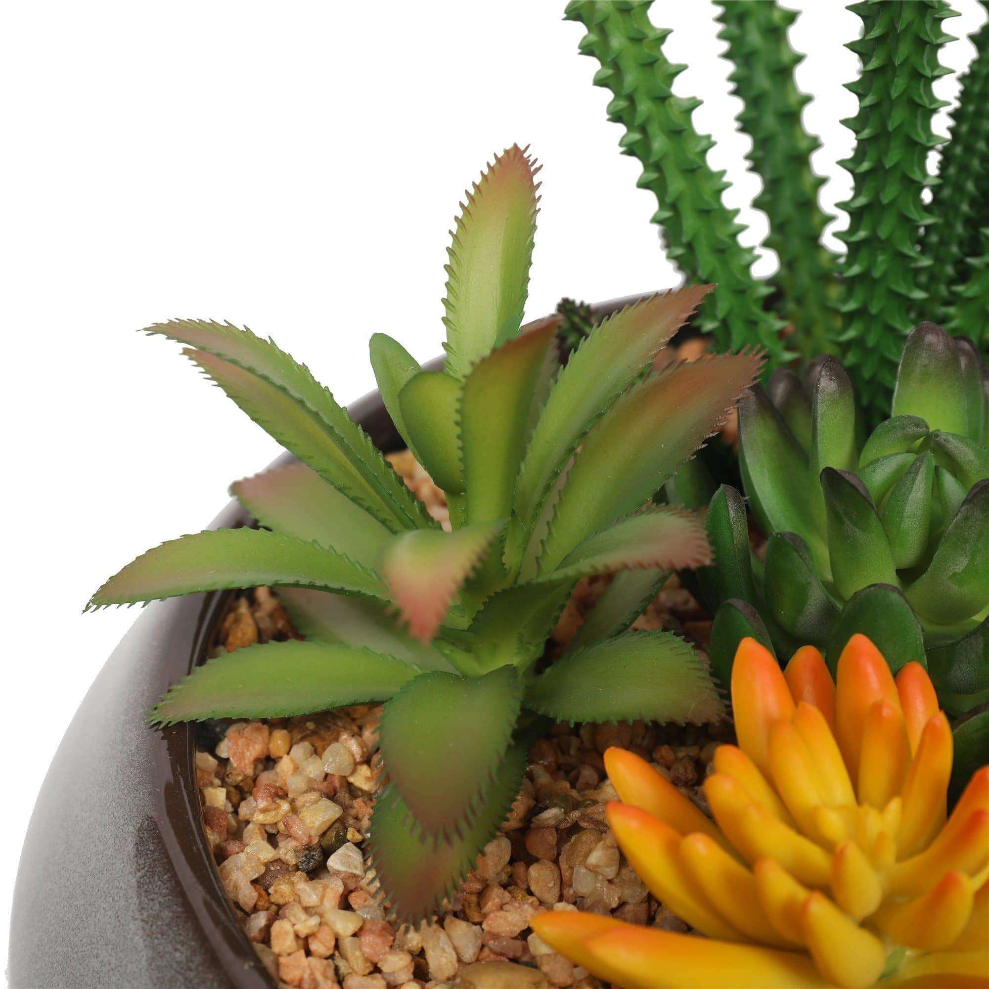 A beautifully arranged potted artificial succulent in a modern round decorative bowl, featuring realistic green succulents and decorative pebbles.