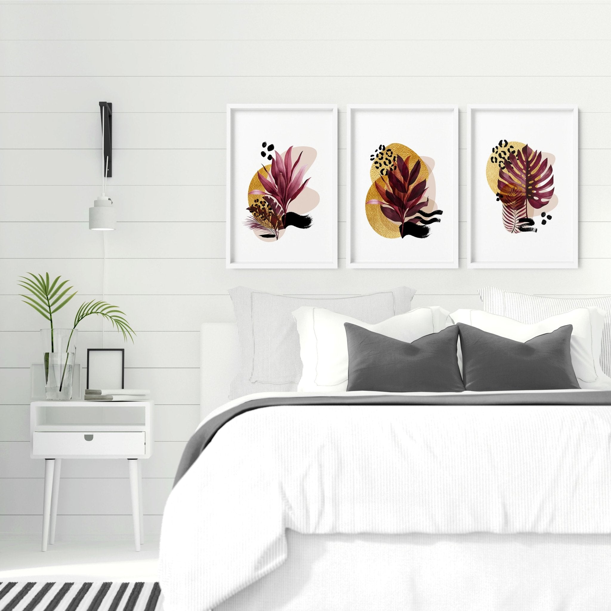 Set of 3 vibrant tropical botanical wall art prints in rich burgundy and gold tones, perfect for bedroom decor.