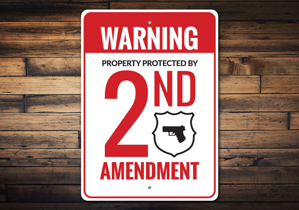 A decorative 2nd Amendment warning sign made of durable aluminum, featuring customizable text options and pre-drilled holes for easy mounting.