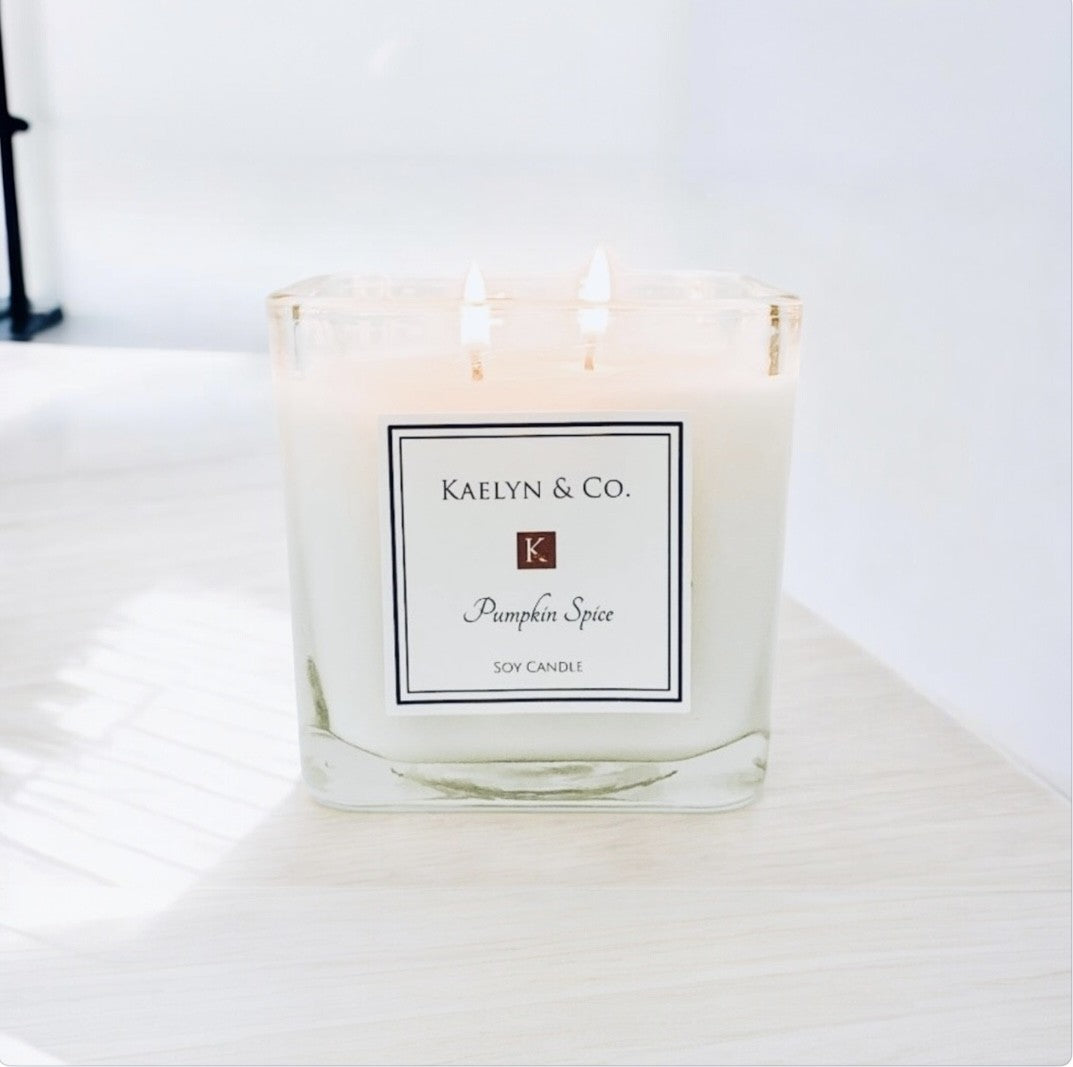 A beautifully crafted Pumpkin Spice Medium Cube Candle in an elegant cube shape, showcasing warm autumn colors and a double wick design.