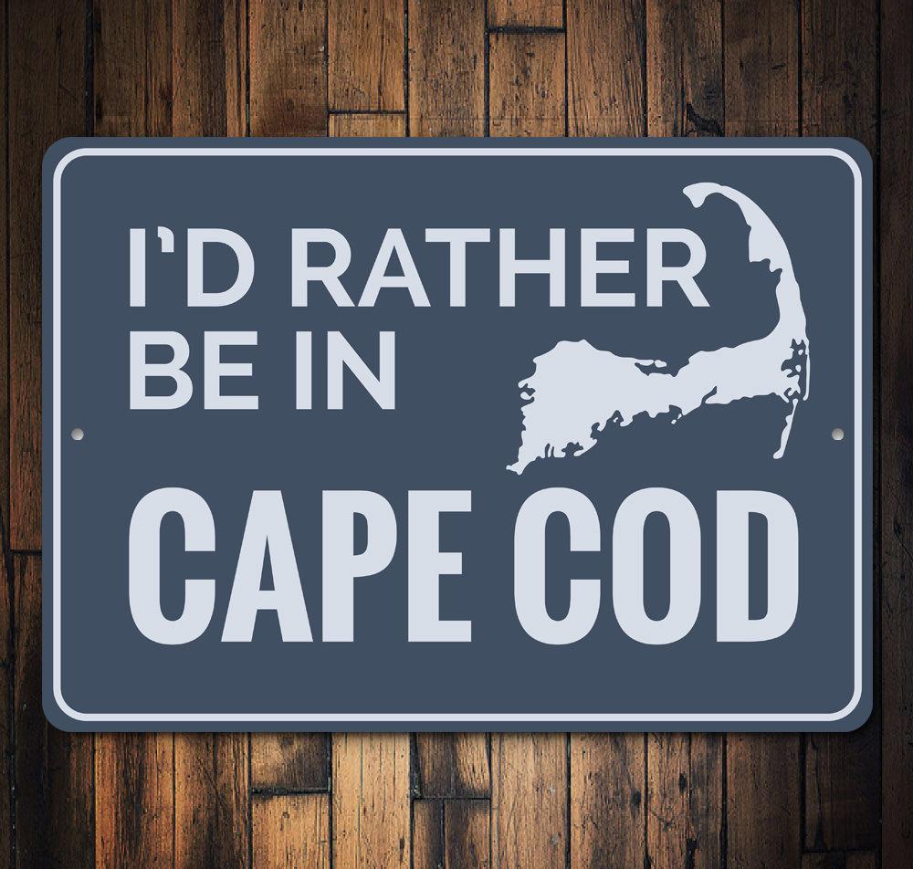 Decorative Rather Be in Cape Cod sign made of aluminum, featuring a beach-themed design, perfect for coastal decor.