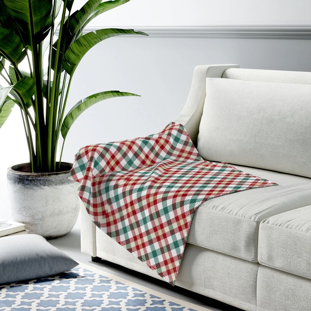 A cozy Red and Green Plaid Plush Blanket Throw draped over a couch, showcasing its soft texture and vibrant colors.