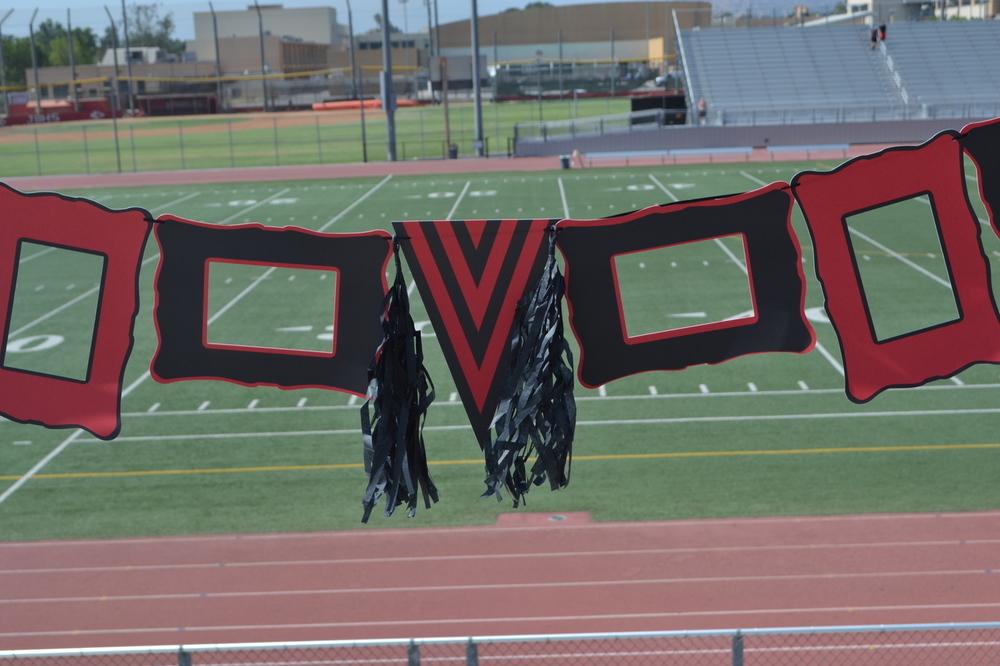 A vibrant Red & Black Collegiate Banner featuring paper frames, a pennant, hanging ribbon, and decorative tassels.