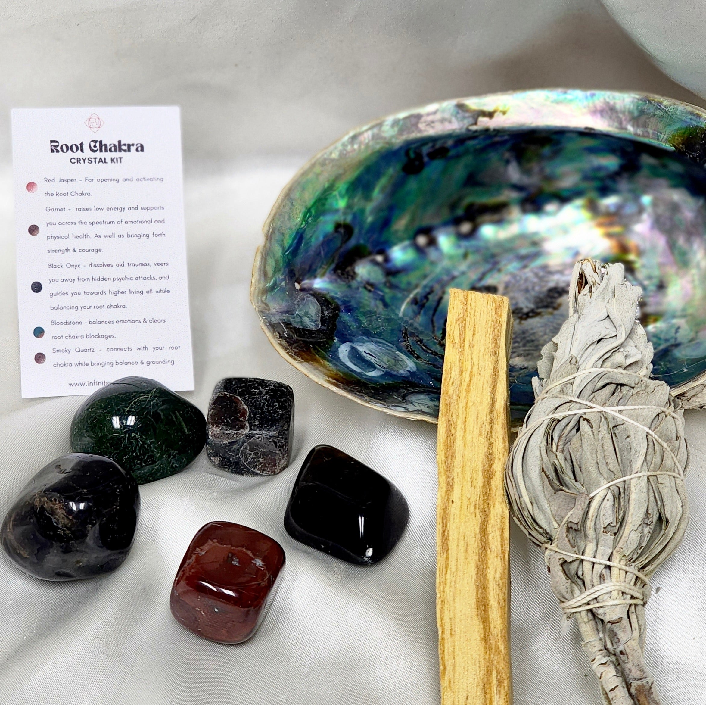 Root Chakra Smudge Kit featuring sage smudge stick, Palo Santo, abalone shell, and assorted healing crystals.