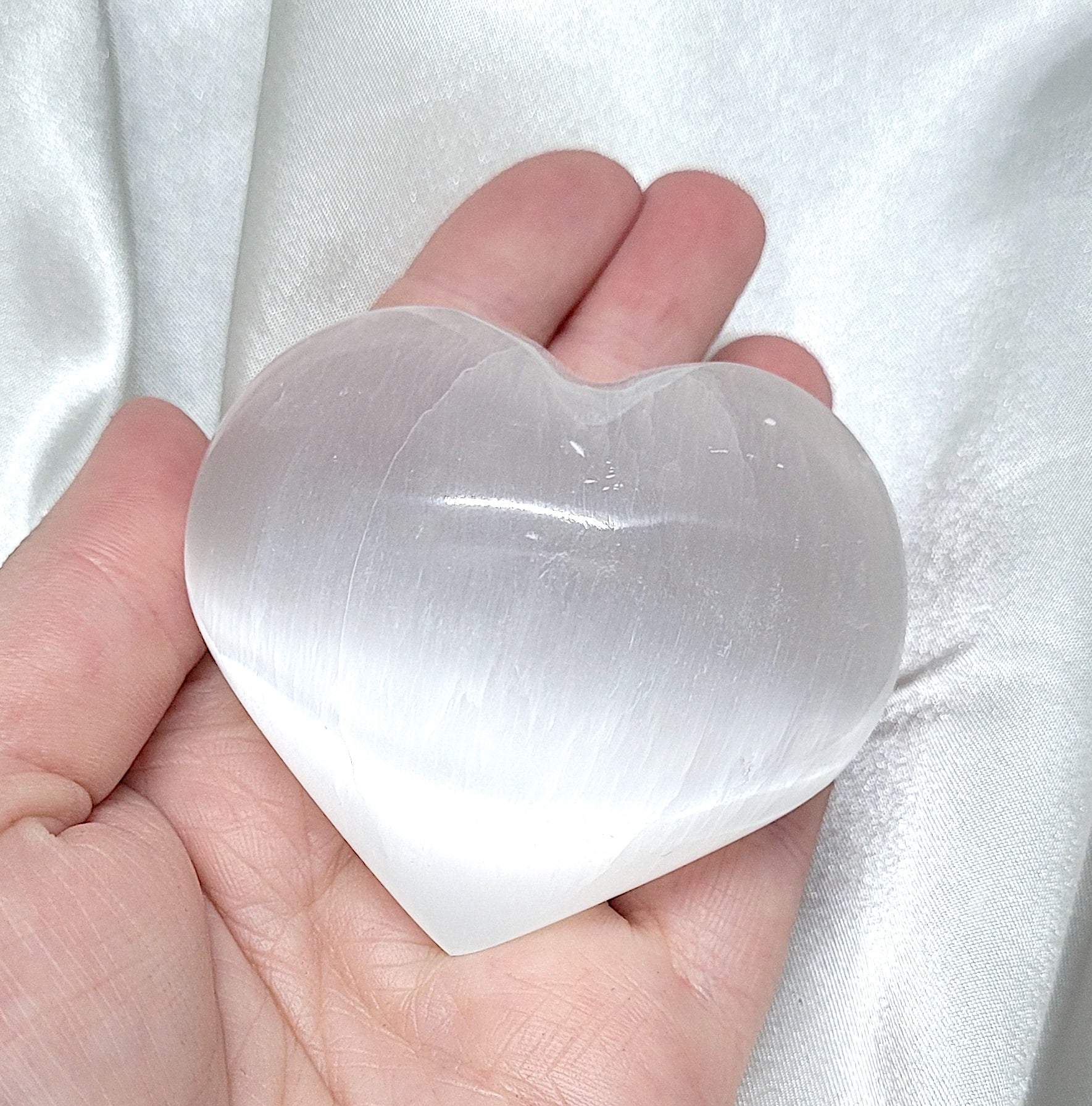 A beautifully crafted Selenite Heart crystal, radiating pure white light and energy, perfect for cleansing and amplifying other crystals.