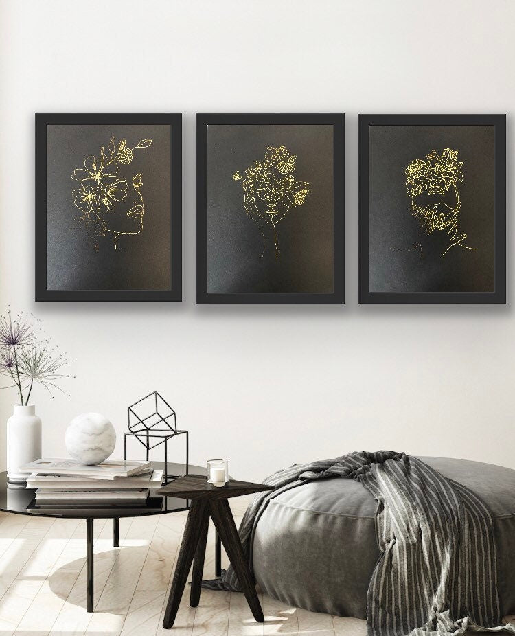 Set of 3 elegant foil prints featuring one line drawings of women's faces in black and gold, showcasing minimalist art style.