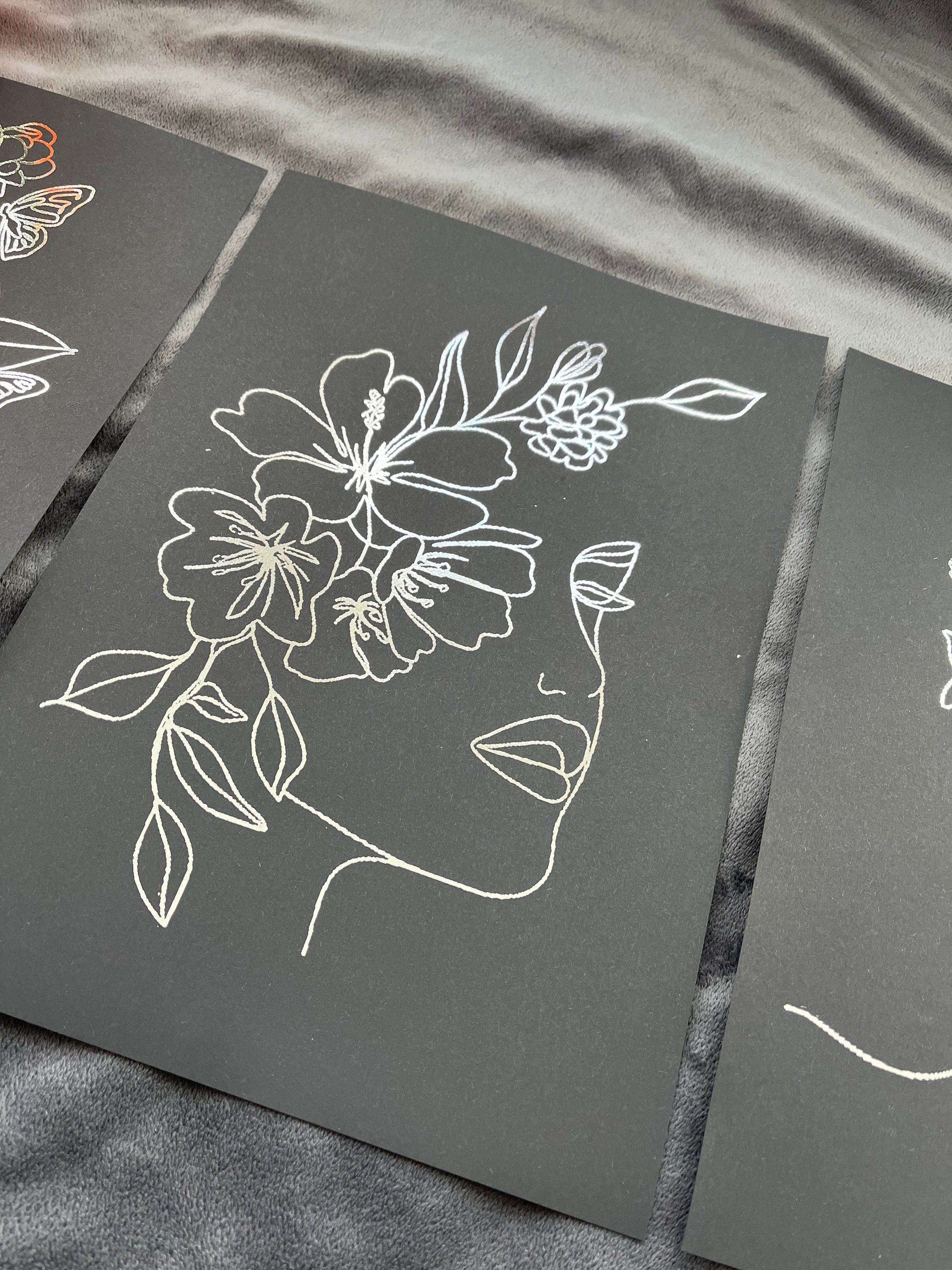 Set of 3 elegant foil prints featuring women's faces in one line drawing style, showcasing a chic black and silver design.